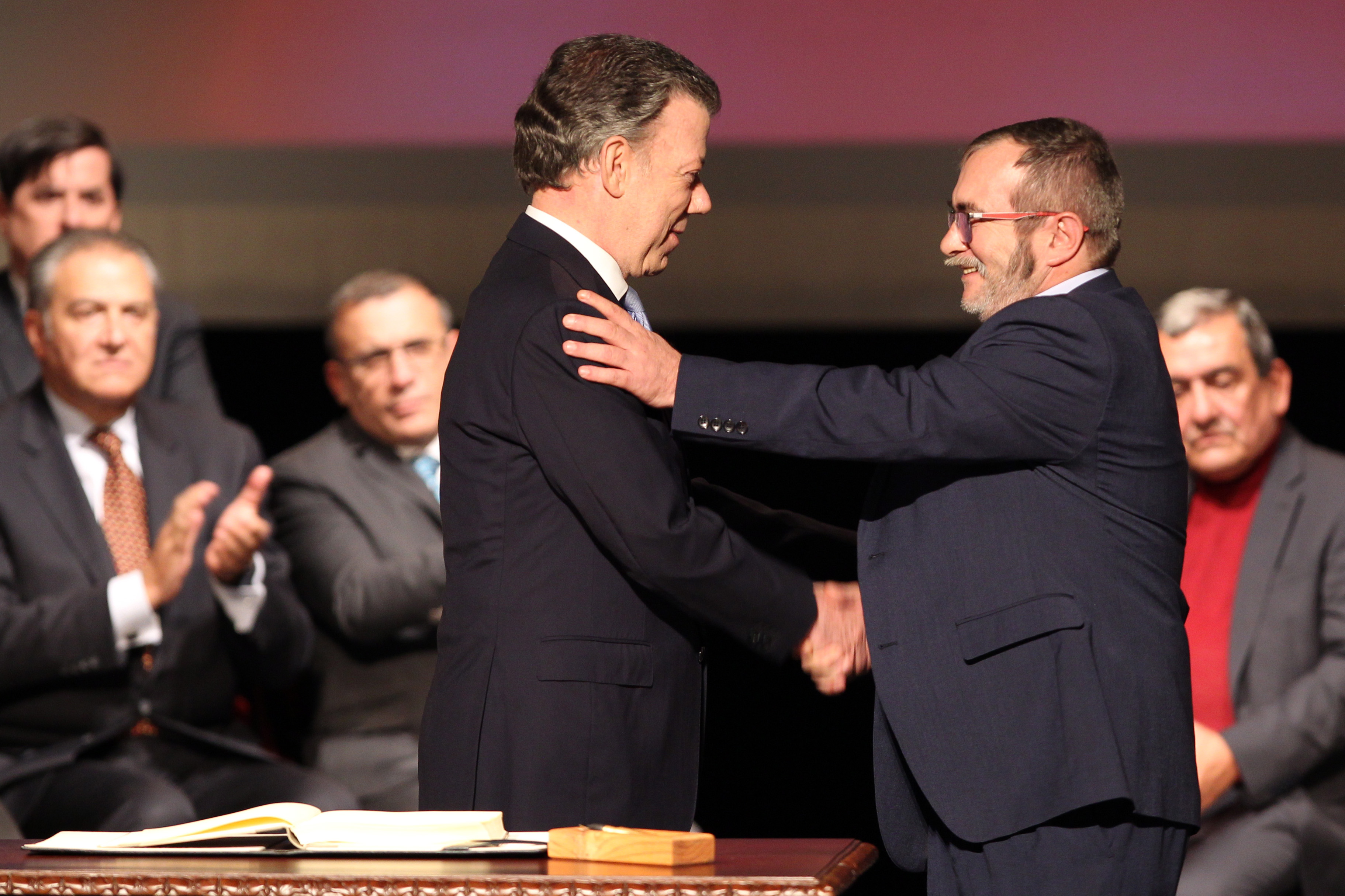 AME525. BOGOTÁ (COLOMBIA), 24/11/2024.- Fotografía de archivo del 24 de noviembre del 2016 que muestra al entonces presidente de Colombia, Juan Manuel Santos (i), y el jefe máximo de las FARC, Rodrigo Londoño Echeverry, mientras se felicitan luego de firmar el acuerdo de paz en el Teatro Colón, para terminar 52 años de conflicto armado interno, en Bogotá (Colombia). El expresidente colombiano Juan Manuel Santos (2010-2018) afirmó que el acuerdo de paz con las FARC, de cuya firma se cumplen este domingo ocho años, sigue vivo por el compromiso de las víctimas, de la sociedad y de la comunidad internacional. EFE/ Mauricio Dueñas Castañeda ARCHIVO