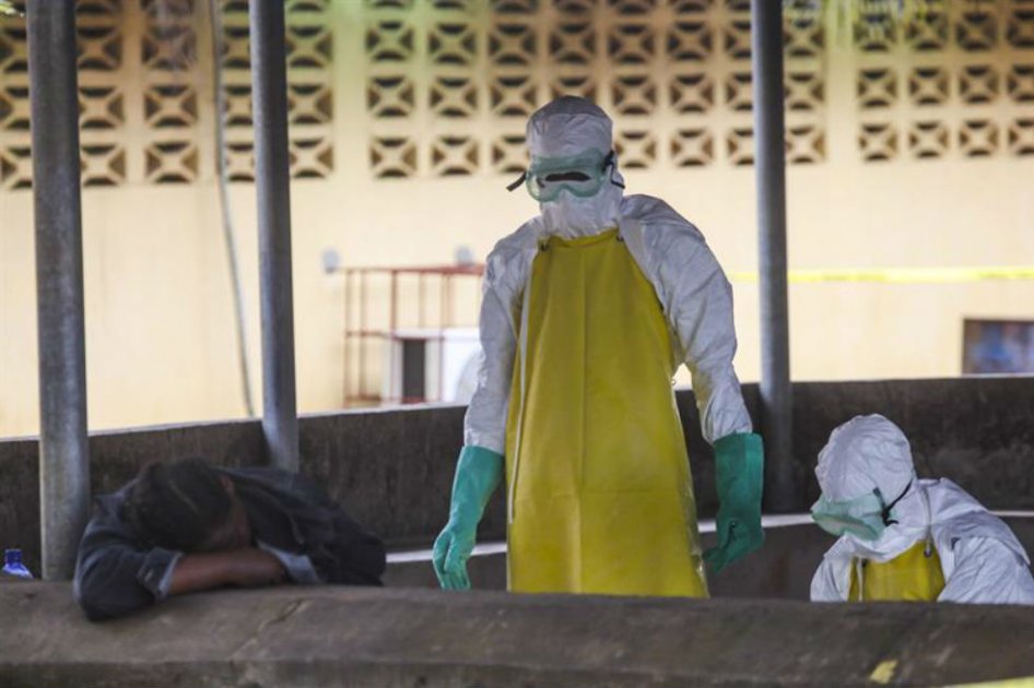 Trabajadores de salud liberianos se preparan para recoger el cuerpo de una víctima del ébola del área de espera de un hospital en Monrovia
