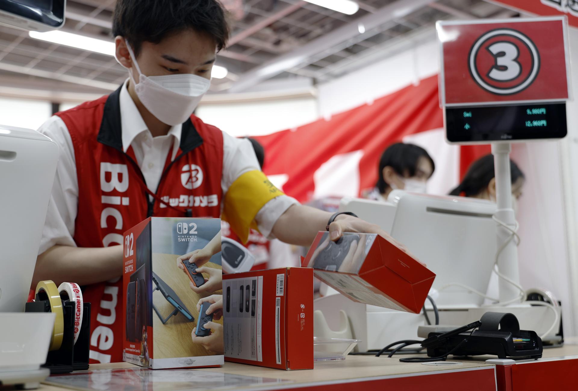 TOKYO (Japan), 05/06/2025.- A store employee prepares the new Nintendo Switch 2 gaming console for a customer at a consumer electronics retailer in Tokyo, Japan, 05 June 2025. On 05 June 2025, Nintendo released its new video game console, the 'Nintendo Switch 2.' This is the first successor model in about eight years since the original Switch was launched in 2017. The first lottery held in April for pre-orders attracted around 2.2 million people in Japan alone. (Japón, Tokio) EFE/EPA/FRANCK ROBICHON