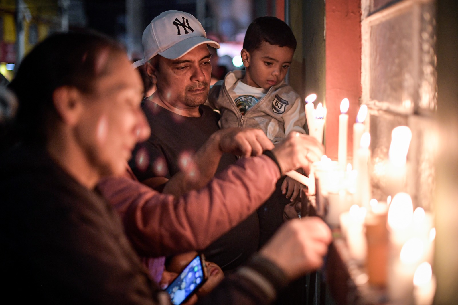 Desde horas de la tarde, los transeúntes y vecinos han encendido velas en las ventanas y puertas de la vivienda en donde ocurrió el doble homicidio.