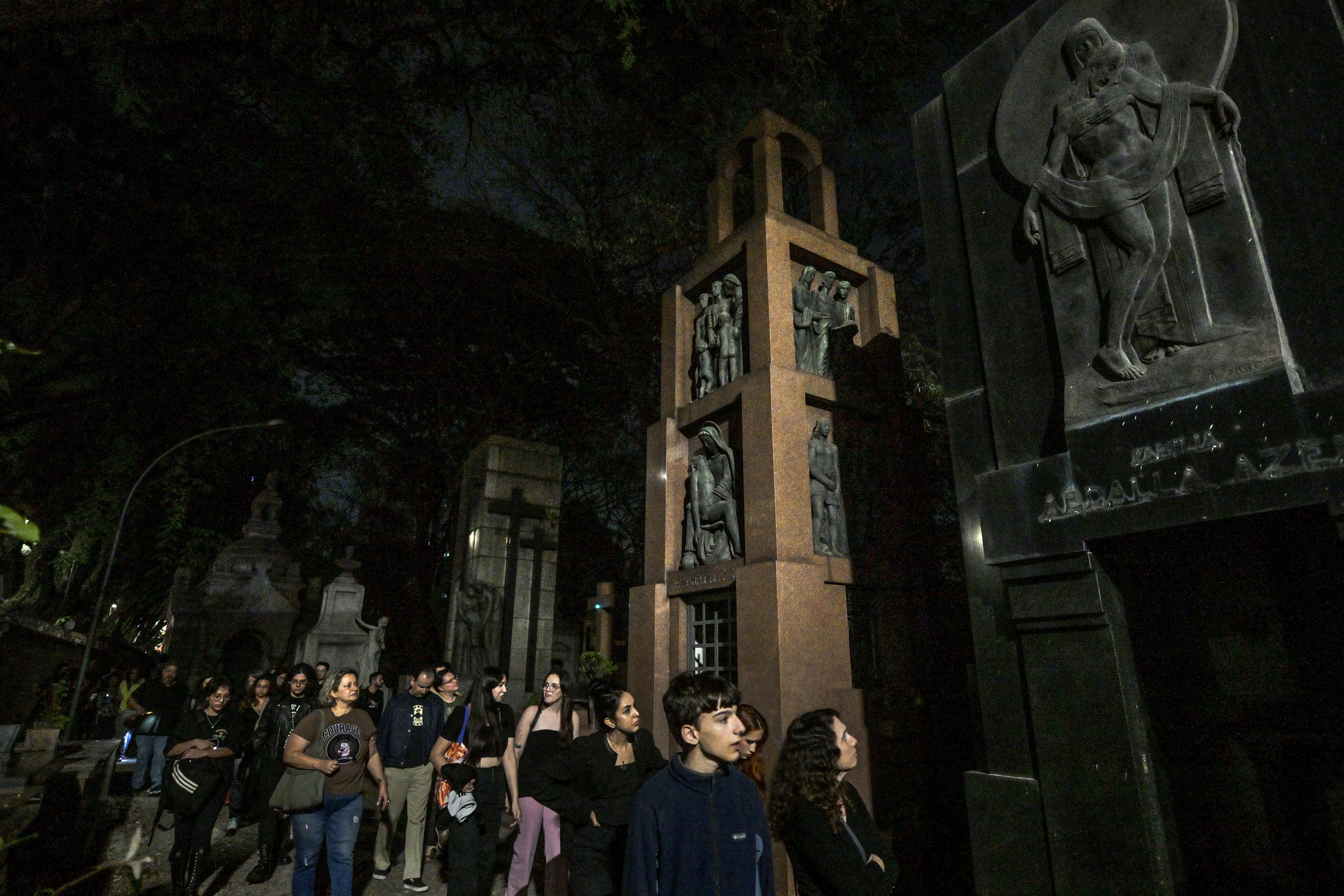 Visitors attend a night guided visit to the Consolacao cemetery, as part of the "O que te assombra?" (What haunts you?) project, in Sao Paulo, Brazil, on July 26, 2024.