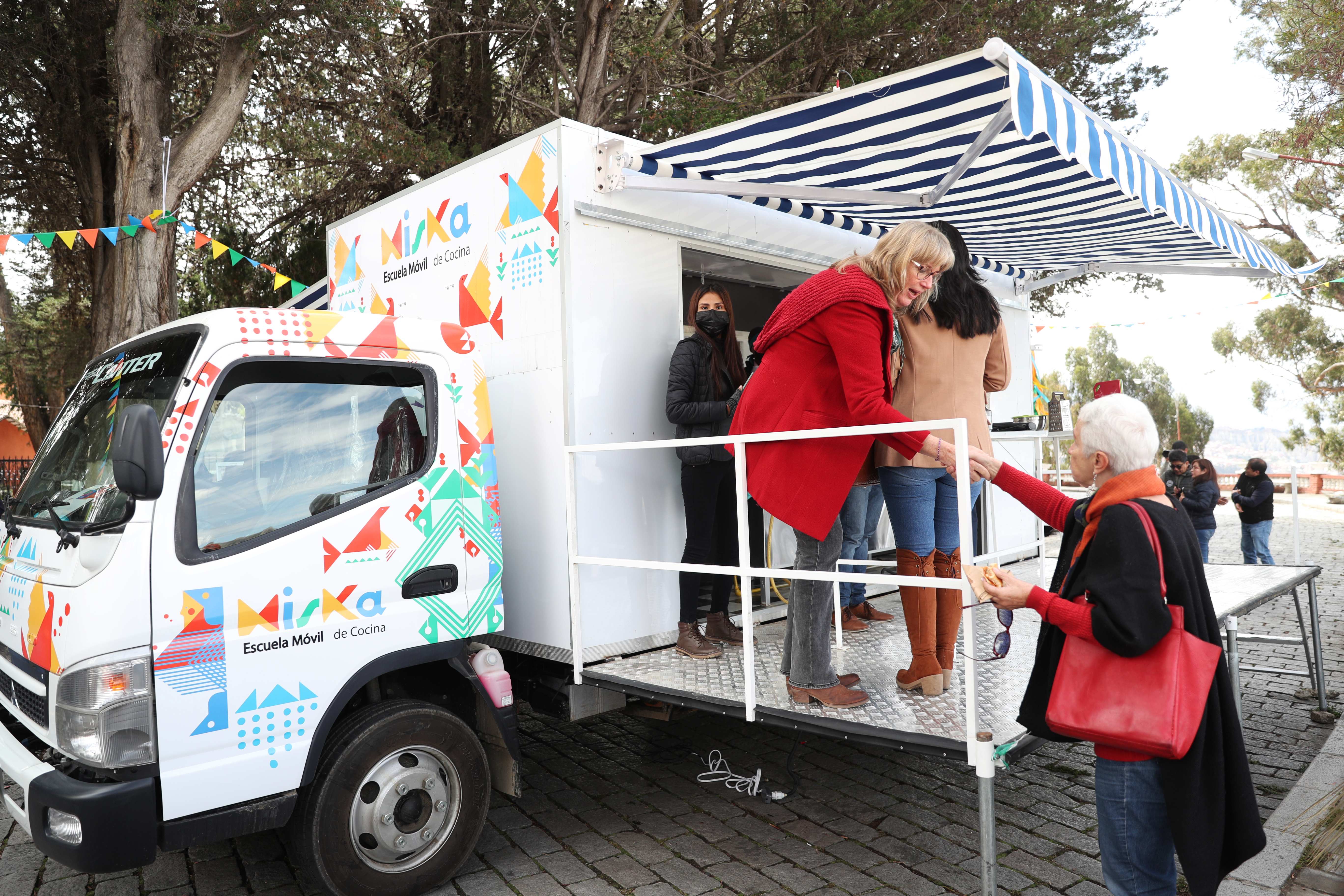 AME8940. LA PAZ (BOLIVIA), 12/05/2023.- Personas se acercan durante la inauguración de la escuela móvil "Miska", hoy, en La Paz (Bolivia). Una formación en gastronomía que no tiene nada que envidiar a la ofrecida en las áreas urbanas llegará a las zonas rurales de Bolivia a través de "Miska", las escuelas móviles montadas en pequeños camiones con las que también se buscará revalorizar las recetas y productos locales. EFE/ Luis Gandarillas