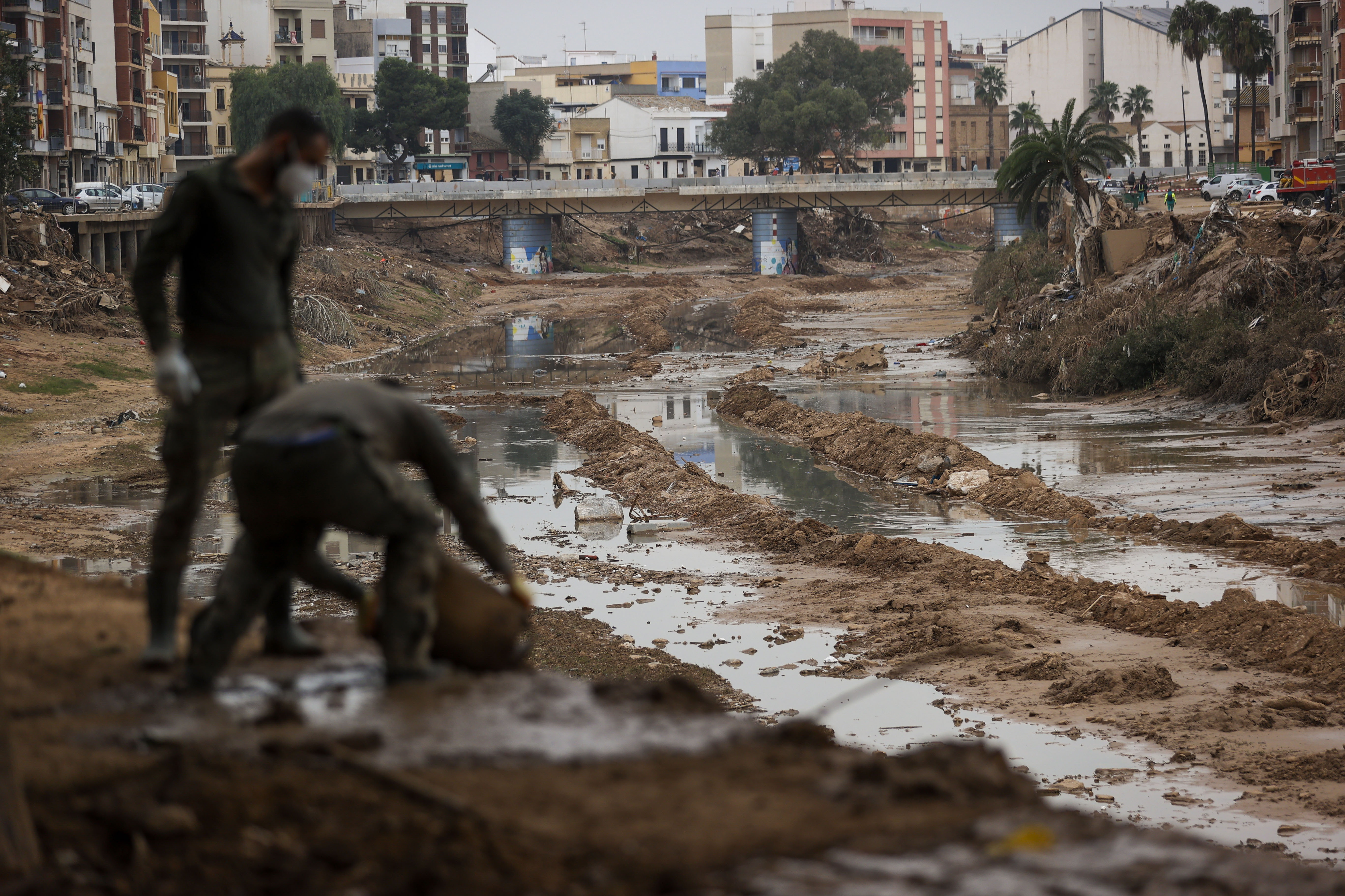 FOTODELDÍA PAIPORTA (VALÈNCIA), 25/11/2024.- Militares vacían un cubo lleno de lodo en el barranco del Poyo, en Paiporta, una de las localidades valencianas afectadas por la tragedia de la dana del pasado 29 de octubre. EFE/ Manuel Bruque
