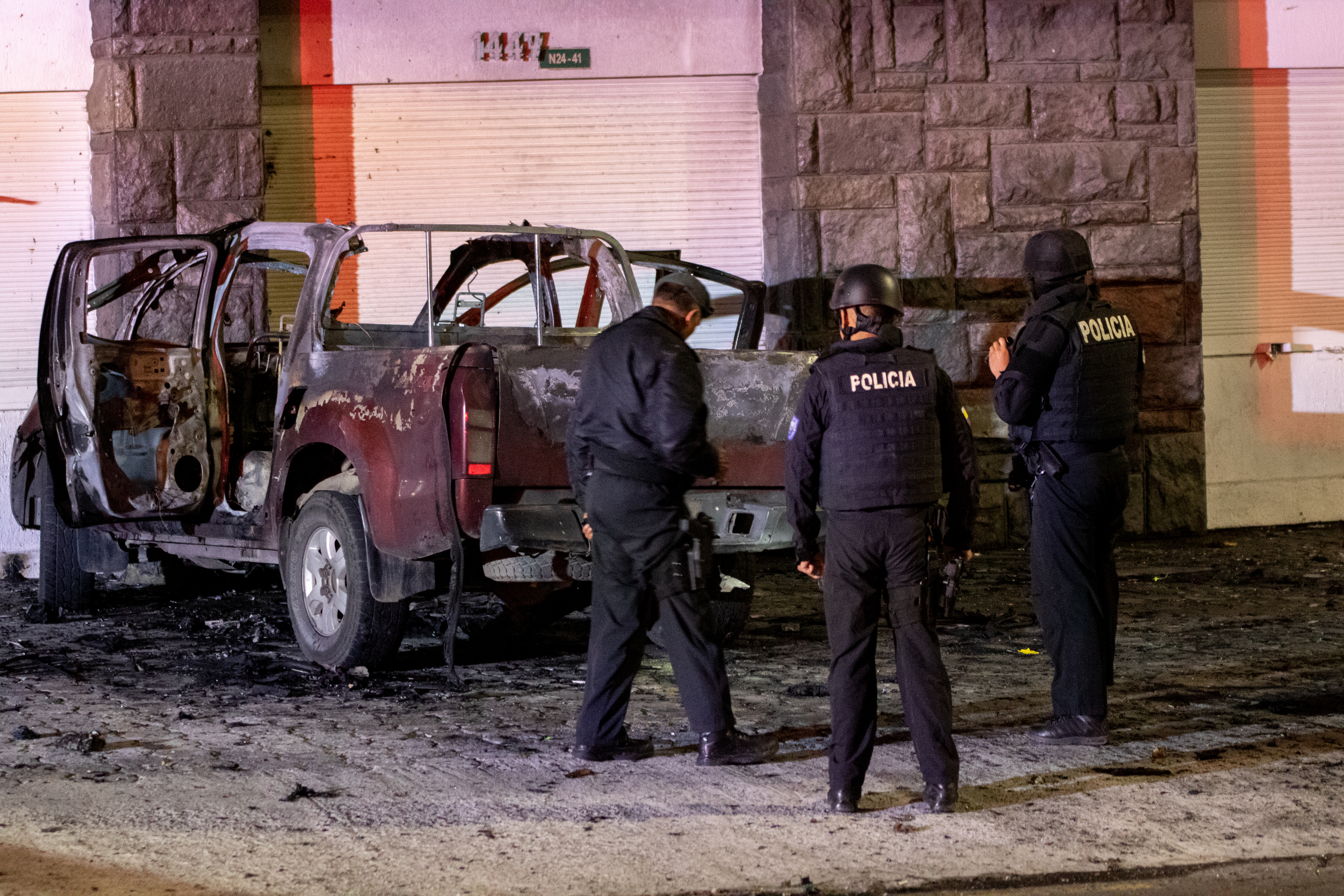 AME5664. QUITO (ECUADOR), 31/08/2023.- Policías investigan los restos de un carro bomba que explotó en la madrugada en los exteriores del edificio del Servicio Nacional de Atención Integral a Personas Privadas de Libertad (SNAI), en Quito (Ecuador). La Policía confirmó que el vehículo incendiado en la madrugada de este jueves en la capital ecuatoriana, Quito, también tenía cilindros de gas en su interior, como el coche bomba que estalló la noche del miércoles en una zona comercial del centro norte de la ciudad. EFE/ Str