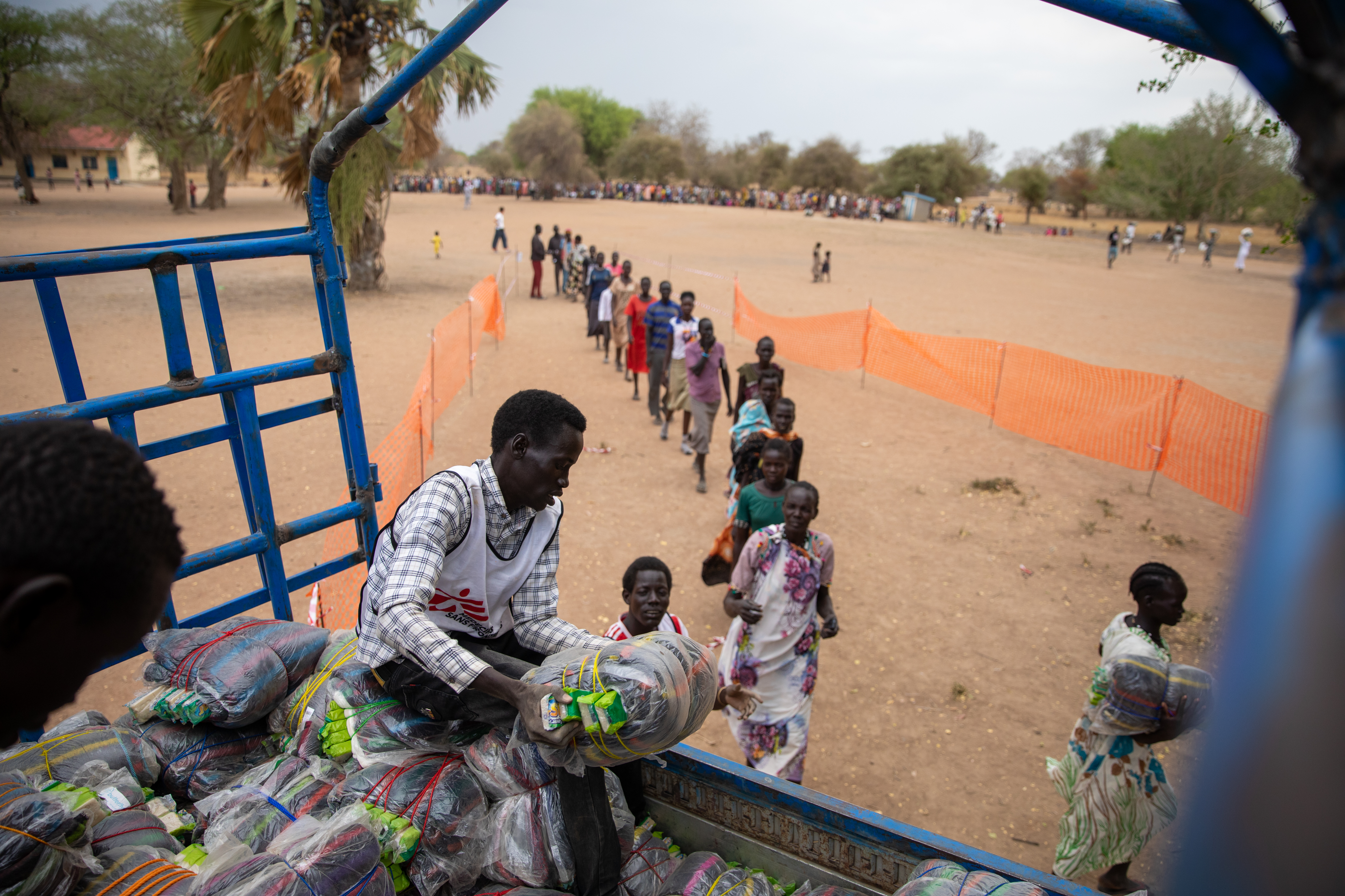 Miembros del equipo de logística de MSF distribuyen mantas y bidones en el campo de desplazados de Nyin Deng Ayuel en el condado de Twic. Después de huir de la violencia en Agok, miles de personas se han quedado sin lo básico para sobrevivir.