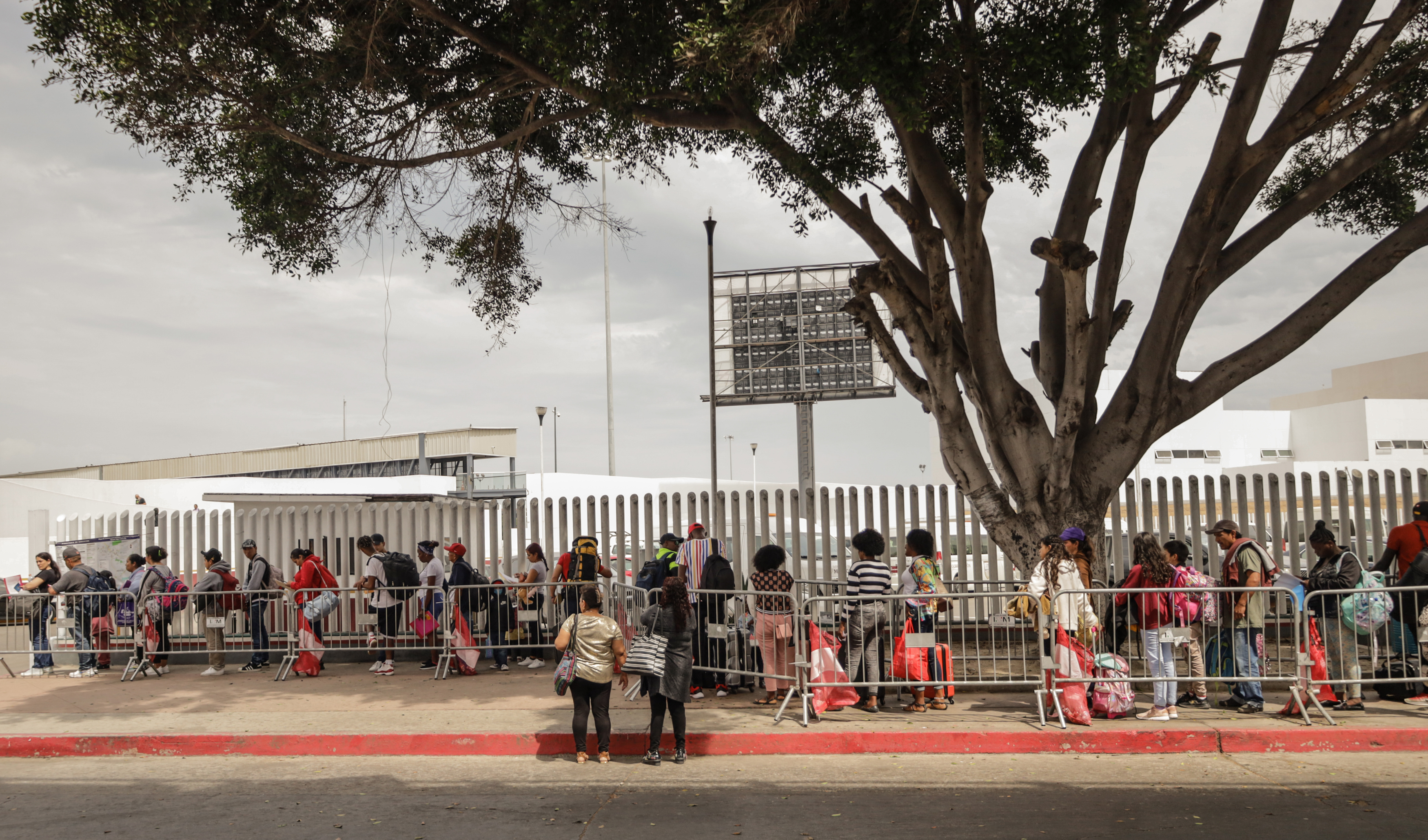 -FOTODELDÍA- MEX1474.TIJUANA (MÉXICO), 31/07/2023.- Migrantes hacen largas filas para solicitar asilo en Estados Unidos, hoy en el puerto fronterizo del Chaparral en Baja California (México). Las organizaciones de defensa de los migrantes Al Otro Lado y Haitian Bridge Alliance, y un grupo de 10 personas solicitantes de asilo ubicados en la ciudad fronteriza de Tijuana, México, presentaron el pasado 27 de julio una demanda colectiva ante un tribunal federal en contra del Gobierno de Joe Biden por el rechazar a las personas que solicitan asilo en los puertos de entrada de la frontera sur de Estados Unidos. EFE/Joebeth Terriquez