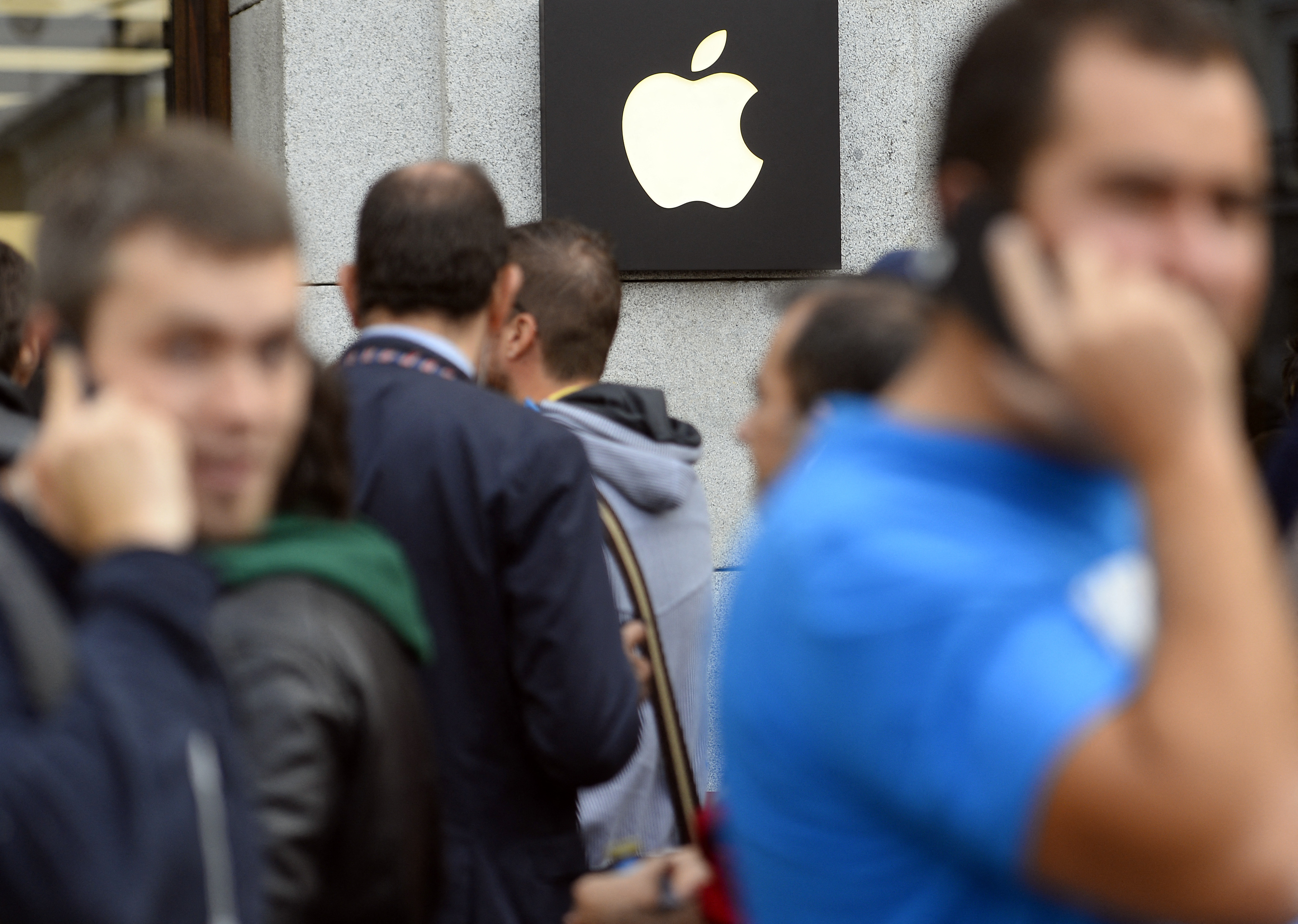 (FILES) People queue to buy the last iPhone 6 in front of the Apple Store of the Puerta del Sol in Madrid on September 26, 2014.