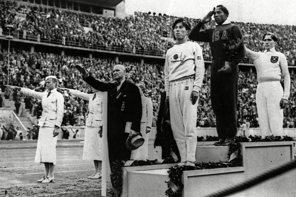 Jesse Owens, en lo más alto del podio en Berlín mientras los alemanes hacen el saludo nazi .