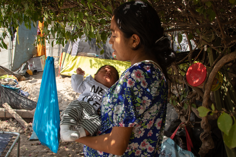 Elizabeth* cargando a su hijo Carlos*. Embarazada, decidió cruzar la frontera nadando el Río Bravo. Al ser capturada por la patrulla fronteriza de Estados Unidos empezó su labor de parto y dio a luz a Carlos. Dos días después ambos fueron deportados a México con la indicación de esperar su proceso de solicitud de asilo en México.
