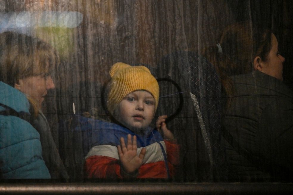 Un niño saluda desde la ventana de un autobús después de cruzar la frontera de Ucrania con Polonia.