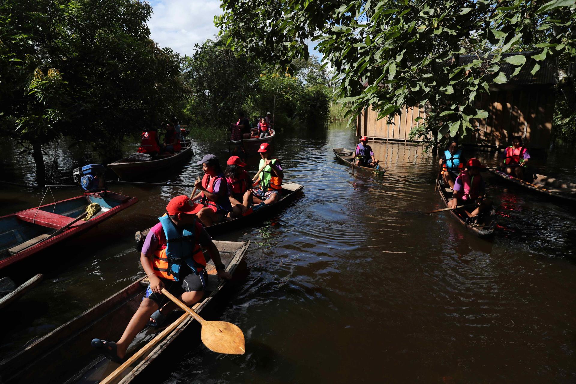 ACOMPAÑA CRÓNICA : PERÚ MEDIO AMBIENTE AME1146. LIMA (PERÚ), 27/05/2025.- Fotografía del 1 de mayo de 2025 de un grupo de niños en canoas dirigiéndose a un vivero por el rio Itaya, en Iquitos (Perú). Un colorido ejército de niños en canoas surge entre la vegetación en el río Itaya, en el corazón de la Amazonía peruana. Al vivir en el pulmón del mundo, saben que la deforestación y el cambio climático no son sólo fenómenos que estudian, sino que sufren directamente sus efectos, por lo que han decidido organizarse y ser herramienta de cambio. EFE/ Paolo Aguilar