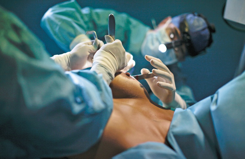 Surgeon Peter Romer performs breast implant surgery on a patient named Laura at his clinic in Caracas, November 5, 2009. Unfazed by a recession and rampant inflation, image-conscious Venezuelans show no signs of cutting back on the facelifts, liposuction, and breast augmentation that have become de rigueur beauty treatments. Picture taken November 5, 2009. REUTERS/Jorge Silva (VENEZUELA HEALTH SOCIETY) TEMPLATE OUT