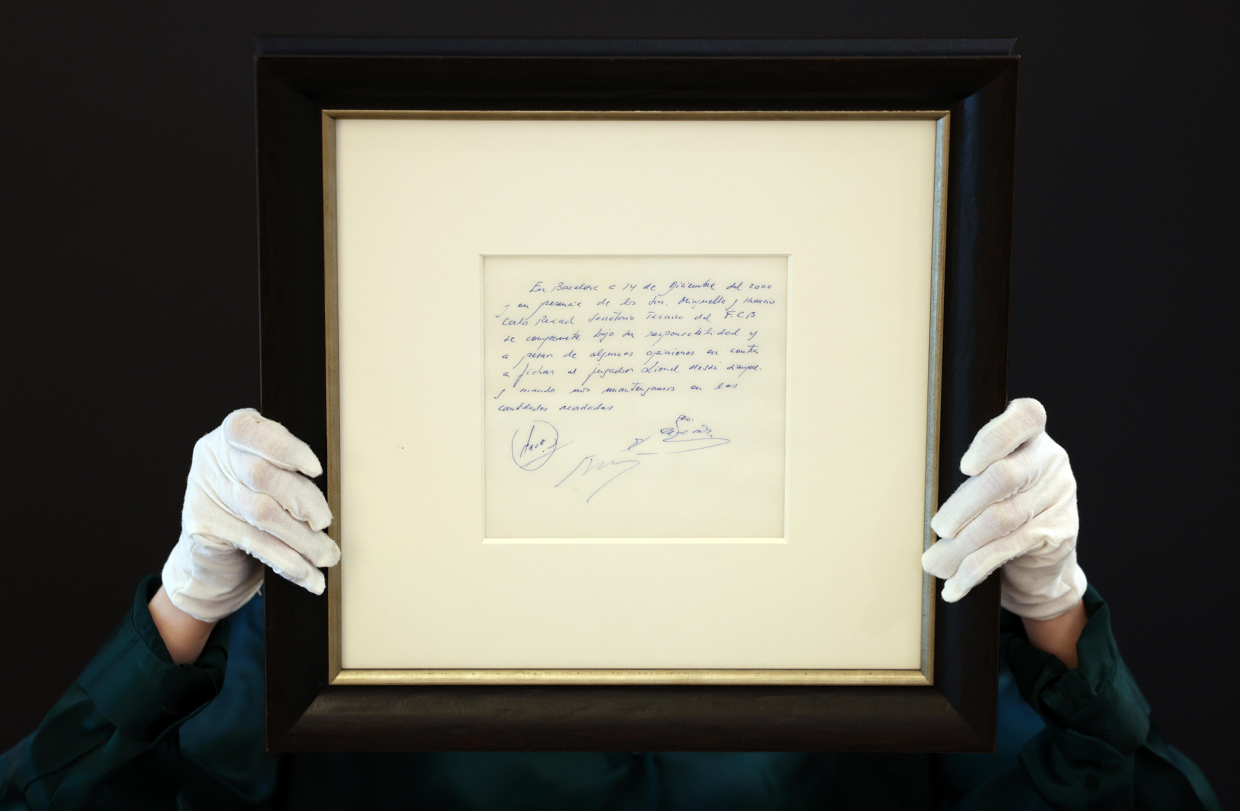 London (United Kingdom), 08/05/2024.- Bonham's auction house staff holds up the Lionel Messi napkin 'contract' for auction at Bonham's in London, Britain, 08 May 2024. The napkin used as a contract or first promise by his father to secure the 13 year old Lionel Messi for Barcelona, is under auction 08-17 May. The napkin and subsequent contract changed the fortunes of Messi, who went on to become one of the greatest soccer players of all time. The napkin is expected to fetch in the region of 300,000 British pounds (around 350,000 euro) . (Reino Unido, Londres) EFE/EPA/ANDY RAIN