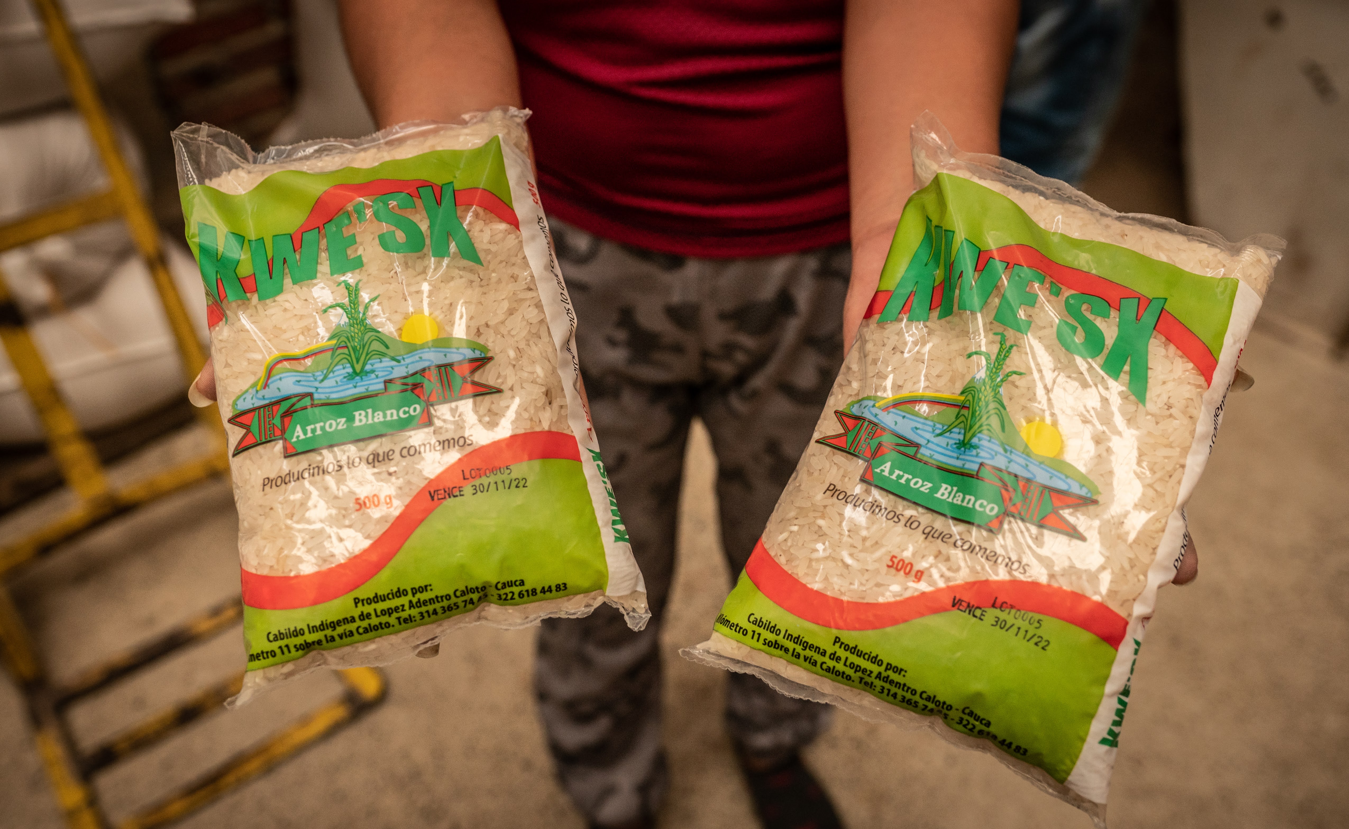 Un indígena muestra la marca propia de arroz que comercializan.