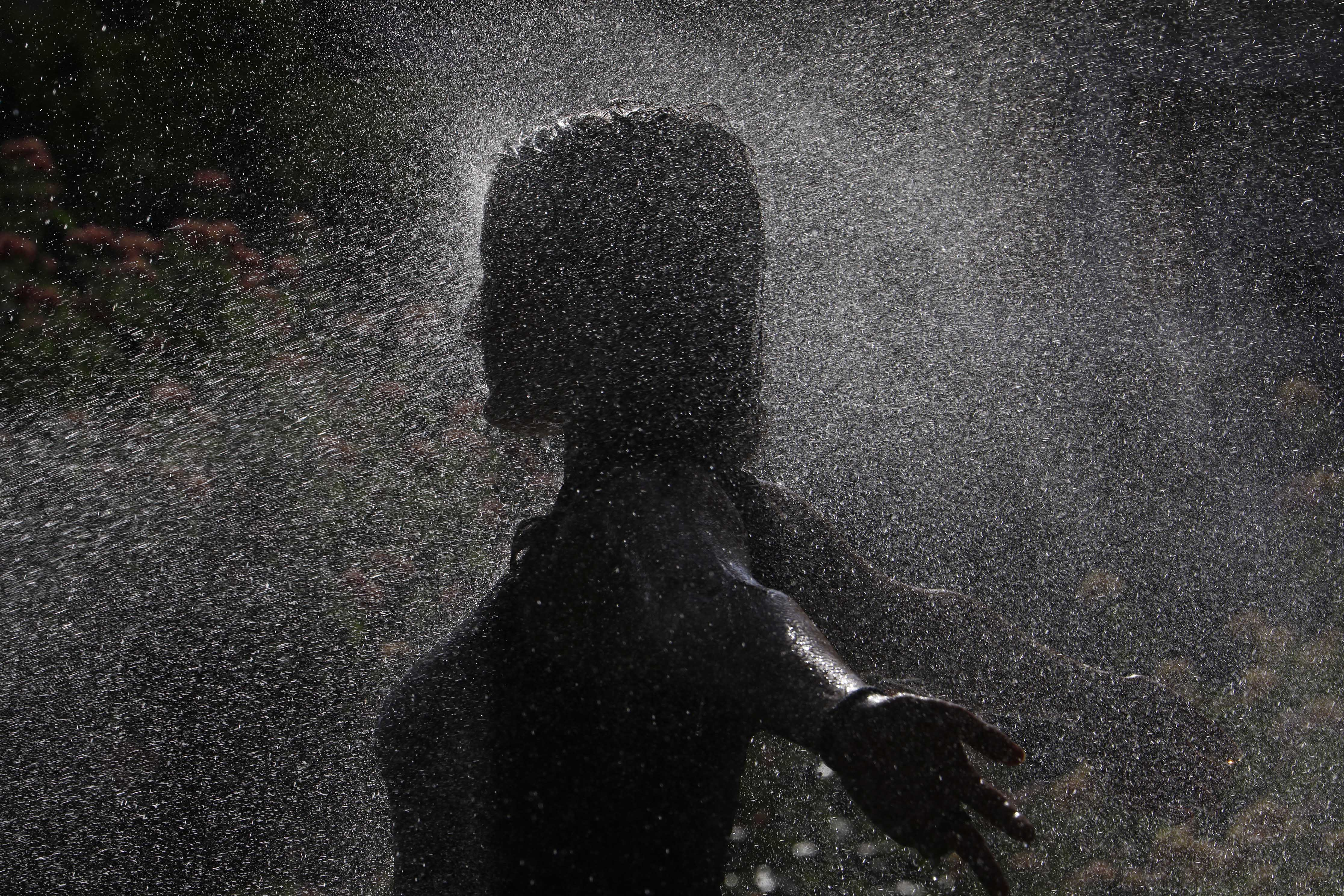 -FOTODELDÍA- CÓRDOBA, 16/07/2022.- Una joven se refresca gracias a varios aspersores para combatir la ola de calor este sábado en Córdoba. La Agencia Estatal de Meteorología (Aemet) pone este sábado en alerta roja a cinco comunidades -Aragón, Cantabria, Extremadura, Navarra y La Rioja- en vista de las altas temperaturas, que podrán llegar a los 44 ºC durante la tarde, y sitúa a otras siete en aviso naranja. EFE/Salas