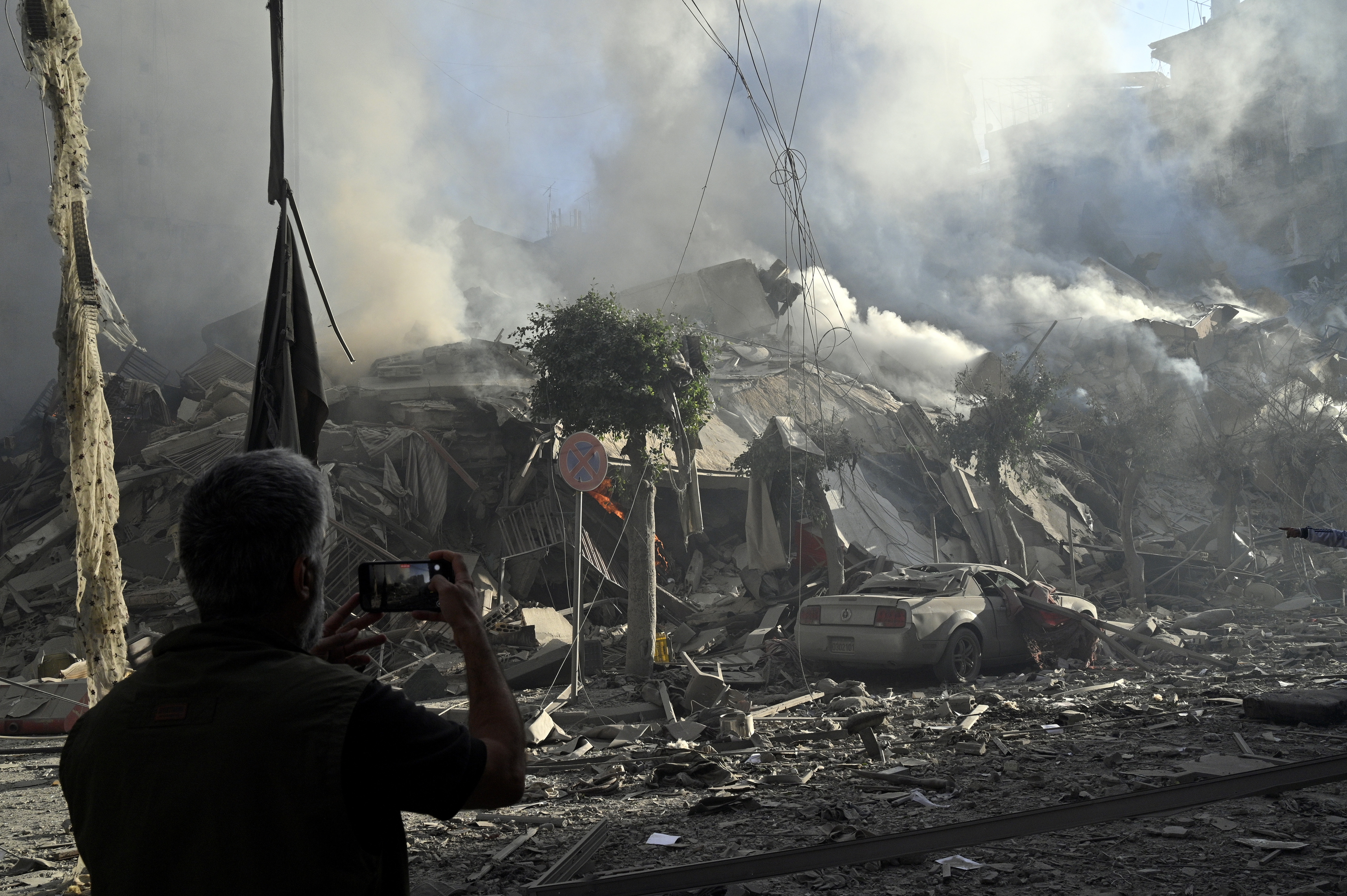 FOTODELDÍA BEIRUT (LIBANO), 03/10/2024.- Un hombre fotografía un edificio humeante después de un ataque aéreo israelí sobre el barrio de Dahieh, uno de los bastiones de Hizbulá, en Beirut (El Líbano) estes jueves. EFE/ Wael Hamzeh