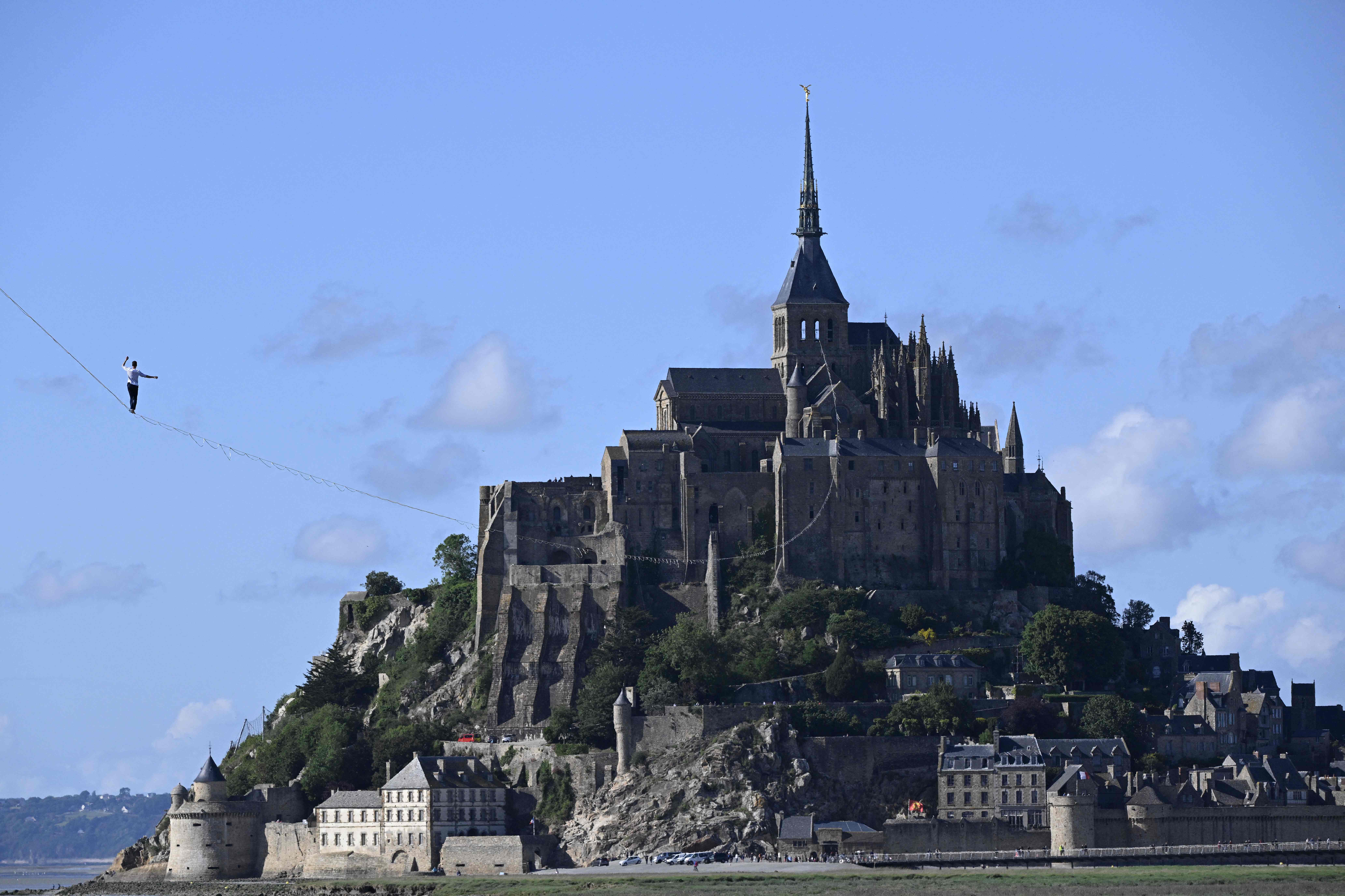 El equilibrista francés Nathan Paulin camina sobre una cuerda floja en la bahía de Le Mont Saint-Michel, en el noroeste de Francia, durante su intento de récord mundial de distancia