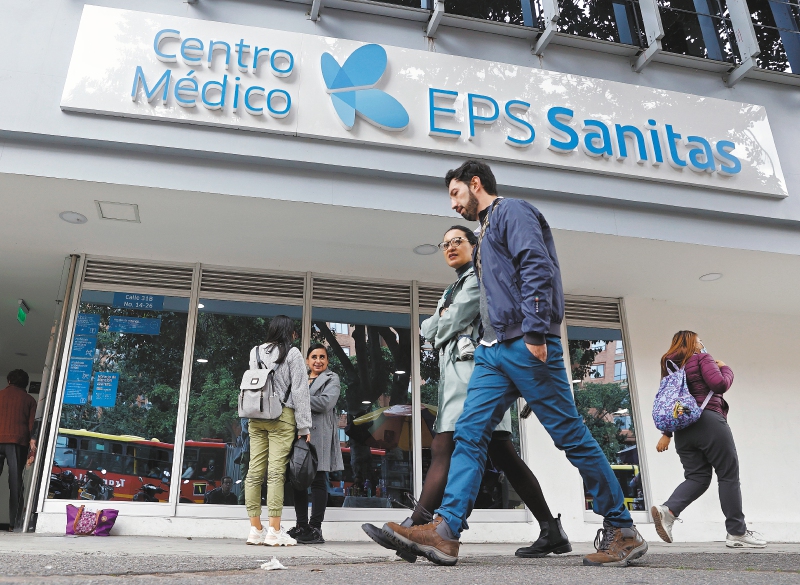Personas caminan frente a un centro médico de la EPS Sanitas en Bogotá. La Superintendencia de Salud intervino el martes 02 de abril, por un periodo de un año, a la entidad prestadora de salud (EPS) Sanitas, a la que están asociadas casi seis millones de personas en Colombia, por supuesta insolvencia en la crisis que enfrentan varias empresas del sector en el país. EFE/Mauricio Dueñas Castañeda