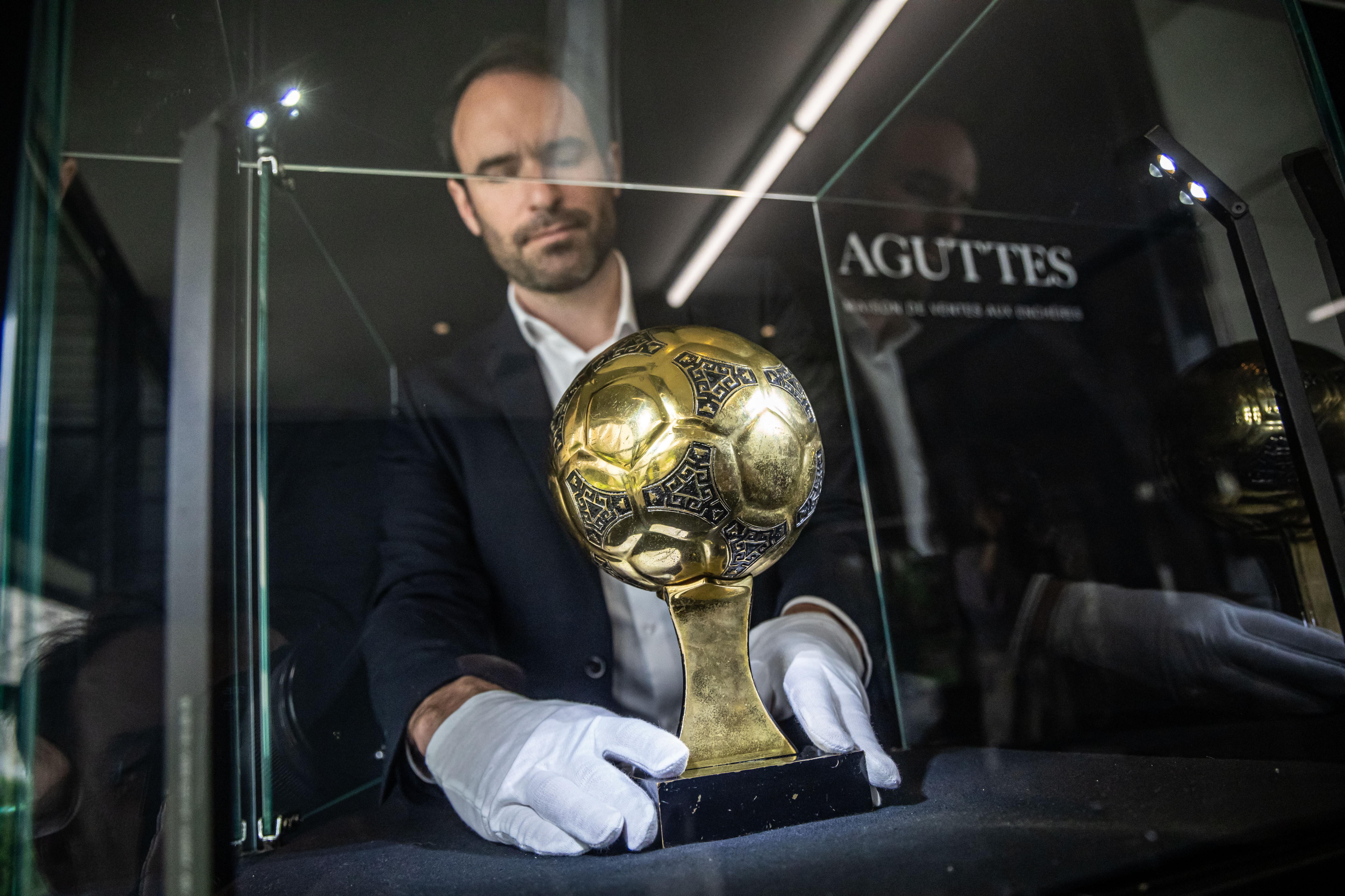 Neuilly (France), 13/05/2024.- Francois Thierry, the sports expert at Aguttes auction house, installs the Diego Maradona's Golden Ball trophy in the case display, the trophy awarded to best player of the 1986 Football World Cup in Neuilly, near Paris, France, 13 May 2024. The original trophy will be auctioned in Neuilly on 06 June 2024. (Francia) EFE/EPA/CHRISTOPHE PETIT TESSON