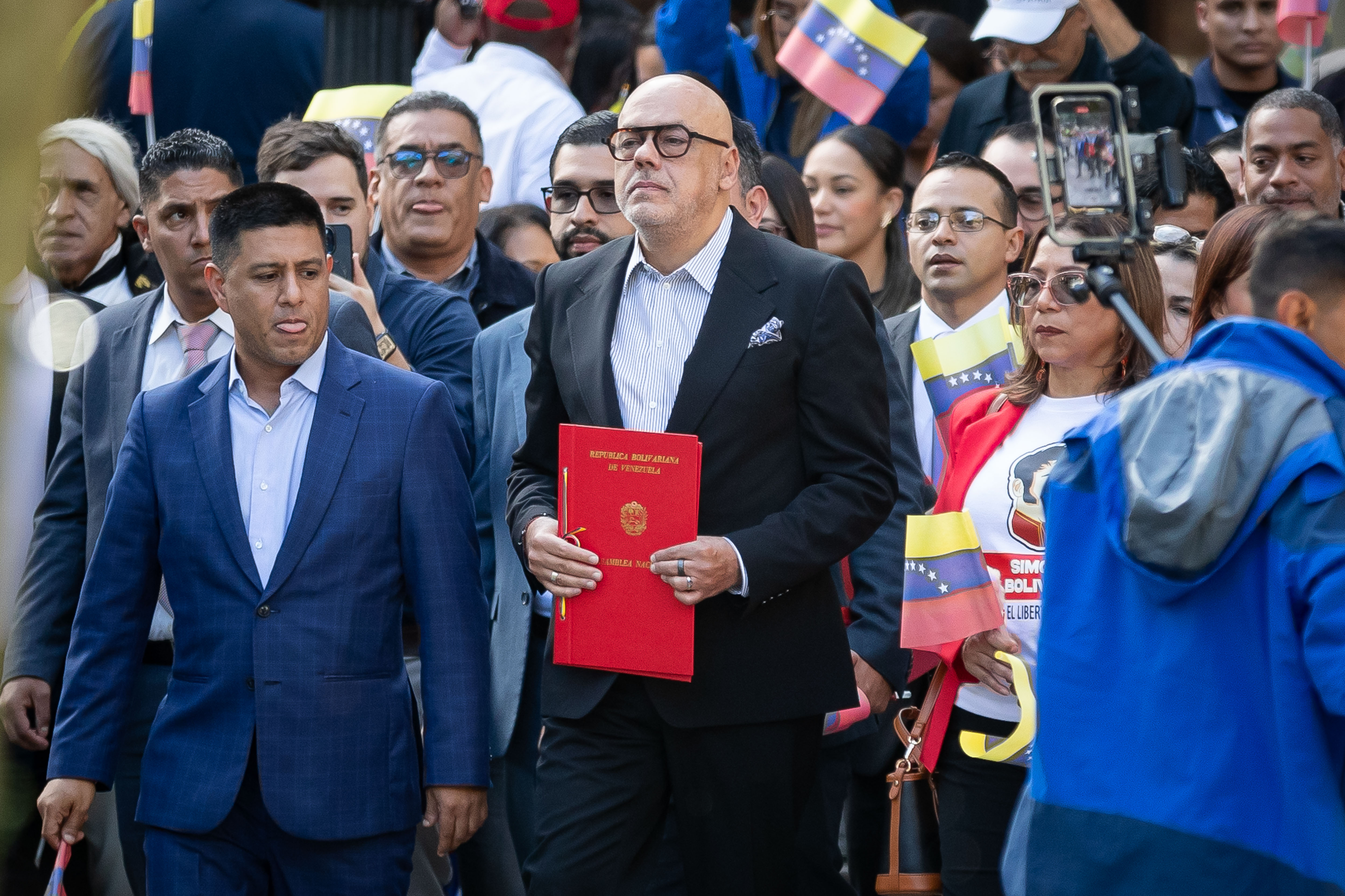 AME1783. CARACAS (VENEZUELA), 28/11/2024.- El presidente de la Asamblea Nacional (AN, Parlamento) de Venezuela, Jorge Rodríguez, sostiene un documento en un acto este jueves, en Caracas (Venezuela). La Asamblea Nacional -controlada por el chavismo- aprobó una ley que ordena penas de entre 25 y 30 años de prisión y multas de hasta un millón de euros (hasta 1.055.680 dólares) para las personas que promuevan o estén implicadas, de cualquier manera, en las sanciones extranjeras impuestas al Gobierno y "autoridades" del Estado. EFE/ Ronald Peña