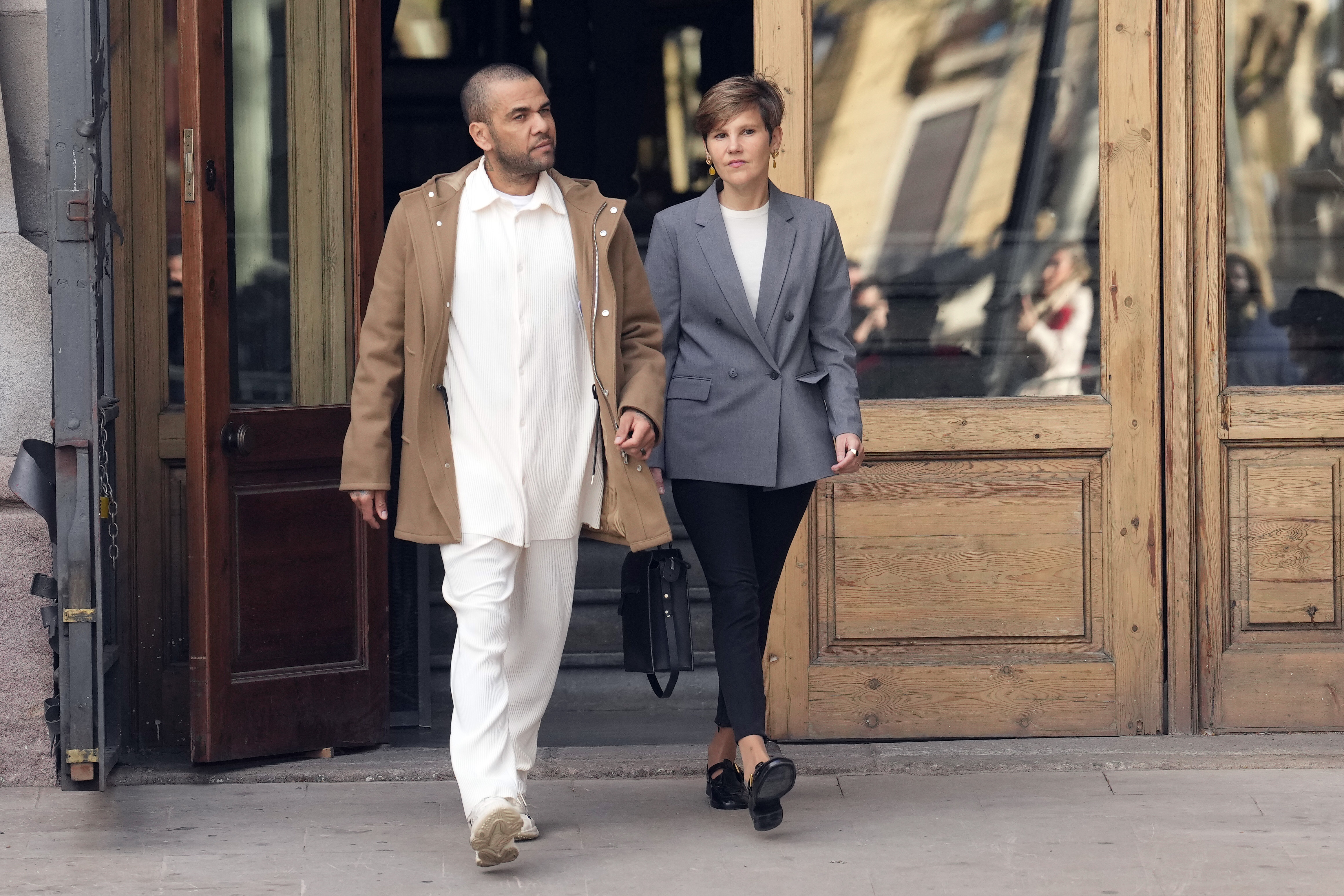 GRAFCAT2018. BARCELONA, 28/03/2024.- El futbolista Dani Alves, en libertad provisional desde el pasado lunes, junto a su abogada Inés Guardiola, a su salida de la Audiencia de Barcelona donde se ha presentado ante la secretaría de la sección 21 de la Audiencia de Barcelona, en la primera de las comparecencias semanales que le impuso el tribunal al fijar una fianza de un millón de euros para permitirle salir de la prisión. EFE/Enric Fontcuberta