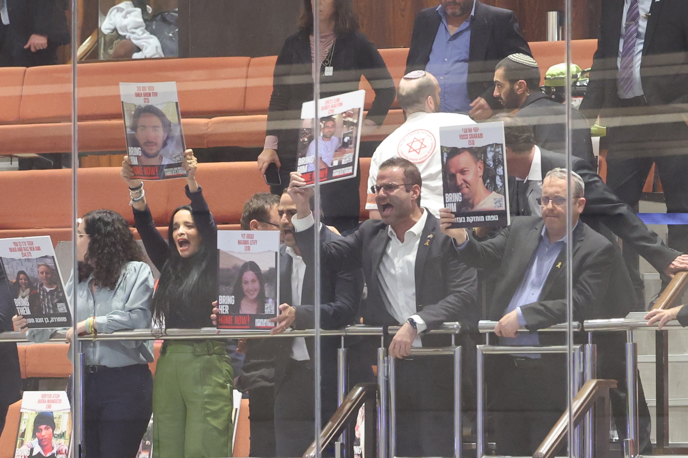Jerusalem (Ó-), 18/11/2024.- Unidentified opposition MPs show pictures of hostages as Israeli Prime Minister Benjamin Netanyahu addresses a discussion called on by the opposition on the release of the Israeli hostages held by Hamas, at the Knesset in Jerusalem, Israel, 18 November 2024. According to Israel's military, around 100 Israeli hostages remain in captivity in the Gaza Strip, including the bodies of 33 confirmed dead. (Jerusalén) EFE/EPA/ABIR SULTAN