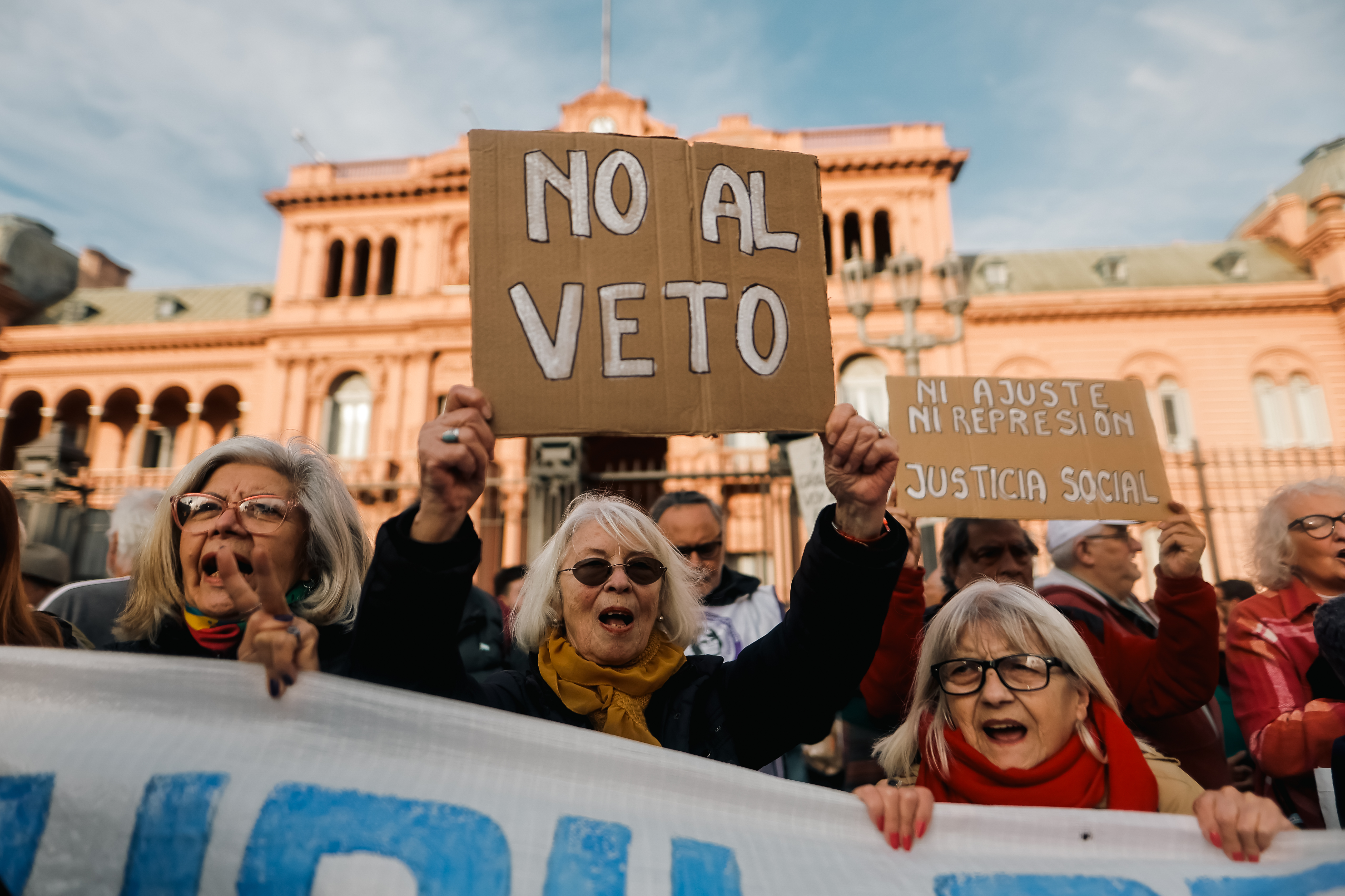 AME4038. BUENOS AIRES (ARGENTINA), 28/08/2024.- Personas sostienen carteles en una manifestación de jubilados este miércoles, en Buenos Aires (Argentina). Una marcha de jubilados en Buenos Aires contra el veto anunciado por el presidente de Argentina, Javier Milei, a un proyecto de ley para modificar la fórmula de actualización de las pensiones fue reprimida este miércoles por la Policía. EFE/ Juan Ignacio Roncoroni