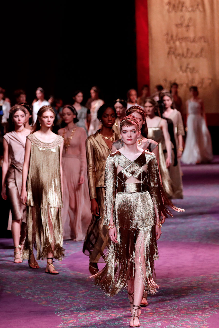 Flecos, pliegues, nudos, cinturones trenzados... la colección de alta costura para la próxima primavera-verano viaja a la antigua capital del imperio romano para presentar delicados vestidos de noche pensados para la alfombra roja. Domina el dorado, pero también los plateados y el rojo. Apenas hay bordados o estampados, el look es minimalista, rematado por finas hojas de laurel de oro que se llevan como pendientes o collares.