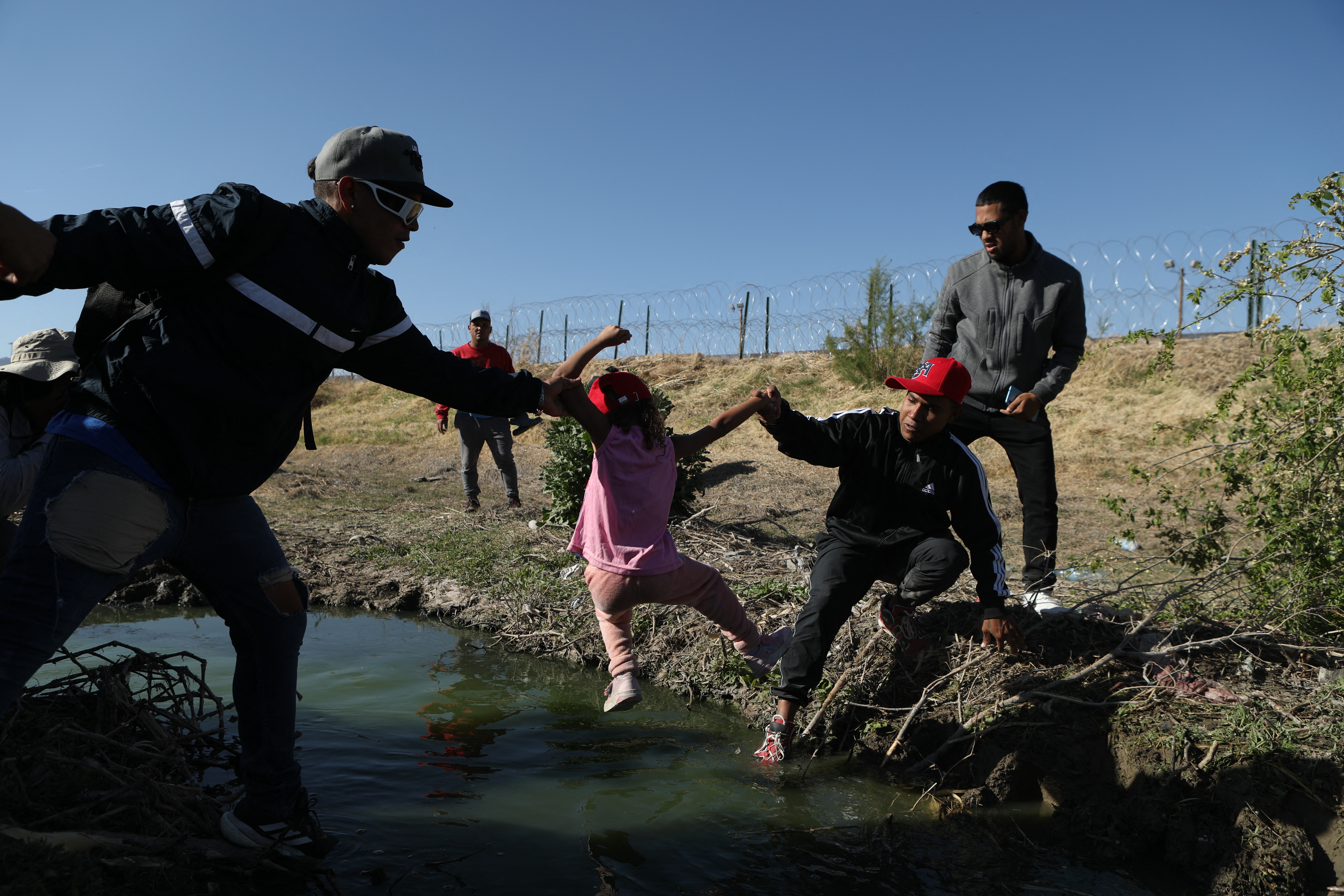 Migrantes cruzan el río Bravo visto desde el lado mexicano de la frontera entre Estados Unidos y México en Ciudad Juárez, estado de Chihuahua, México.