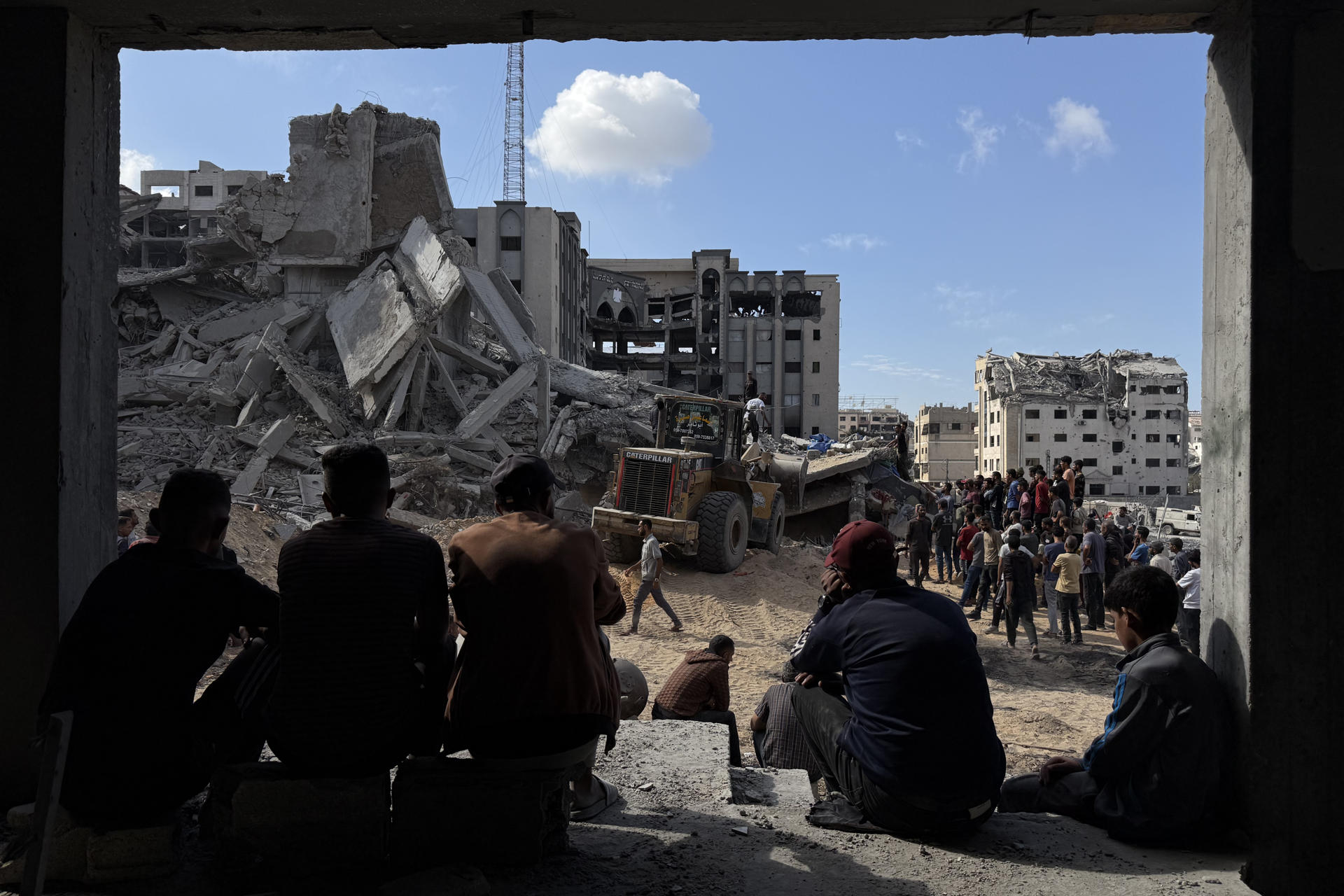 FOTODELDÍA GAZA, 29/10/2025.-Un grupo de gazatíes observa los trabajos de rescate de cuatro personas (un padre y sus tres hijas), de entre los escombros tras un ataque aéreo israelí contra el edificio donde se refugiaban. Un total de 100 personas murieron, entre ellas 35 niños, en los bombardeos israelíes en la Franja palestina de Gaza, tras la reanudación anoche de los ataques del Ejército israelí en el enclave en lo que su Gobierno califica de violaciones del alto el fuego por Hamás.-EFE/ Ahmad Awad
