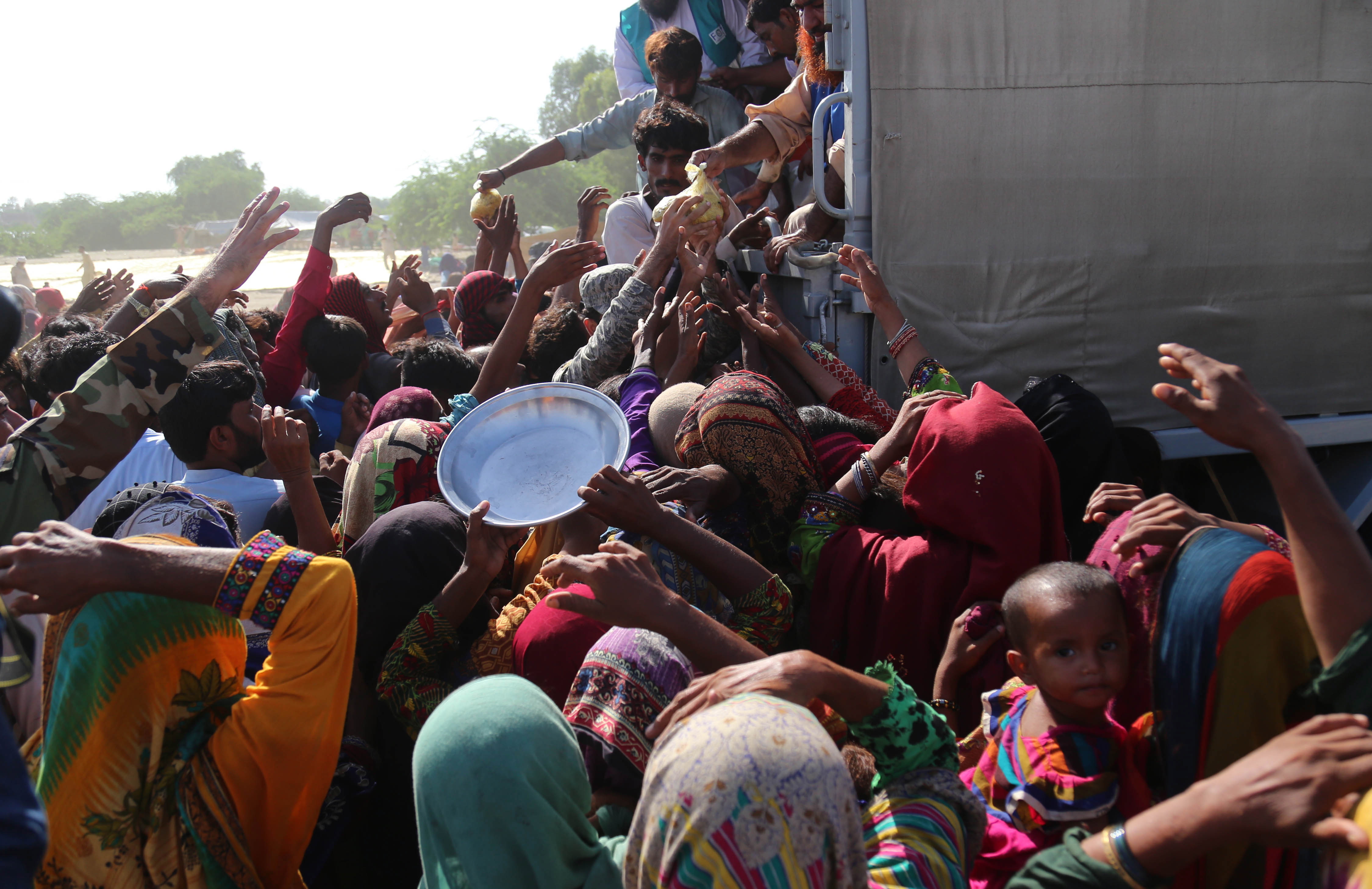 Sehwan (Pakistan), 01/09/2022.- People affected by floods receive aid in Sehwan, Sindh province, Pakistan, 01 September 2022. According to the National Disaster Management Authority (NDMA) on 27 August, flash floods triggered by heavy monsoon rains have killed over 1,000 people across Pakistan since mid-June 2022. More than 33 million people have been affected by floods, the country's climate change minister said. (Inundaciones) EFE/EPA/REHAN KHAN