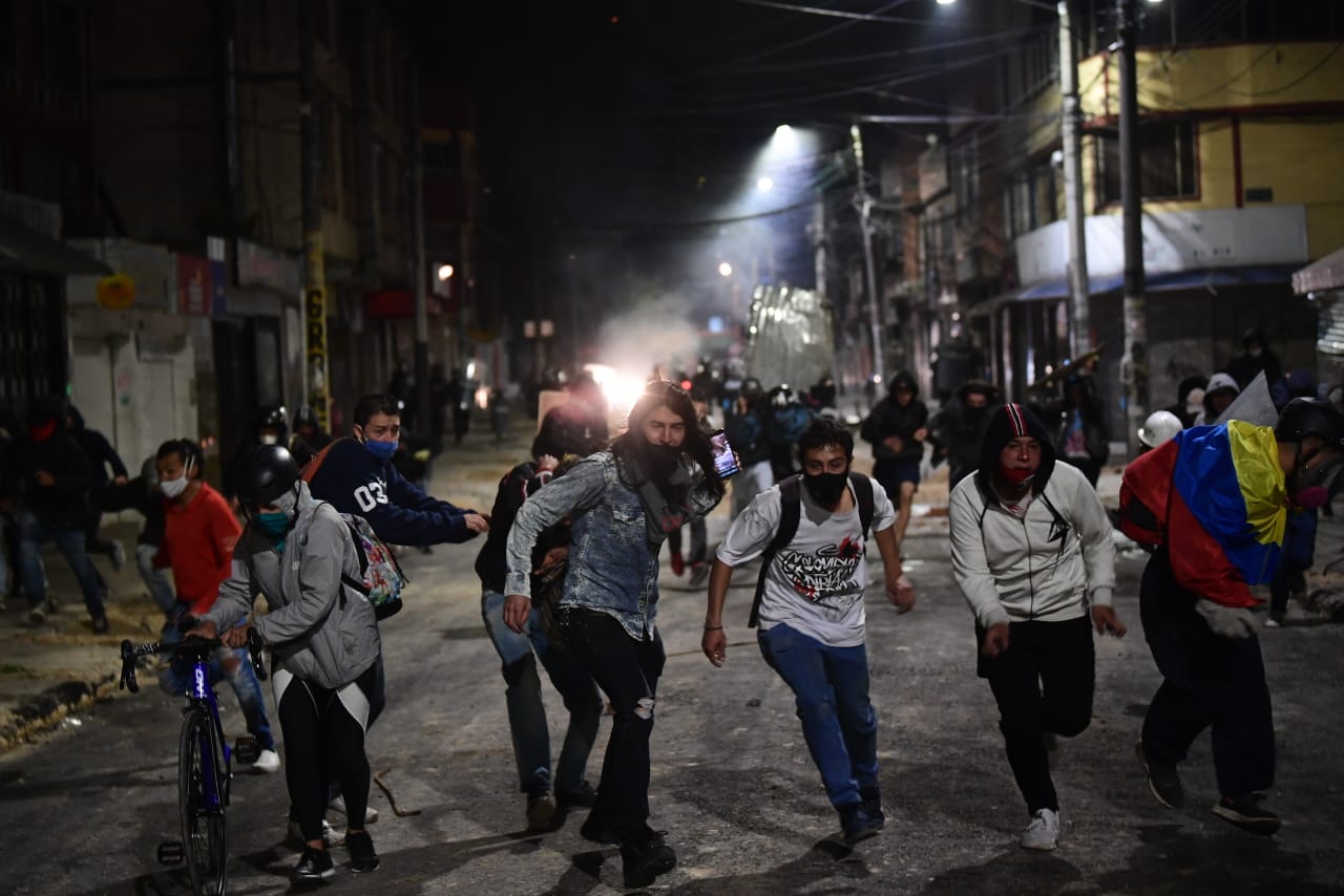 Un grupo de personas encapuchadas corren de frente