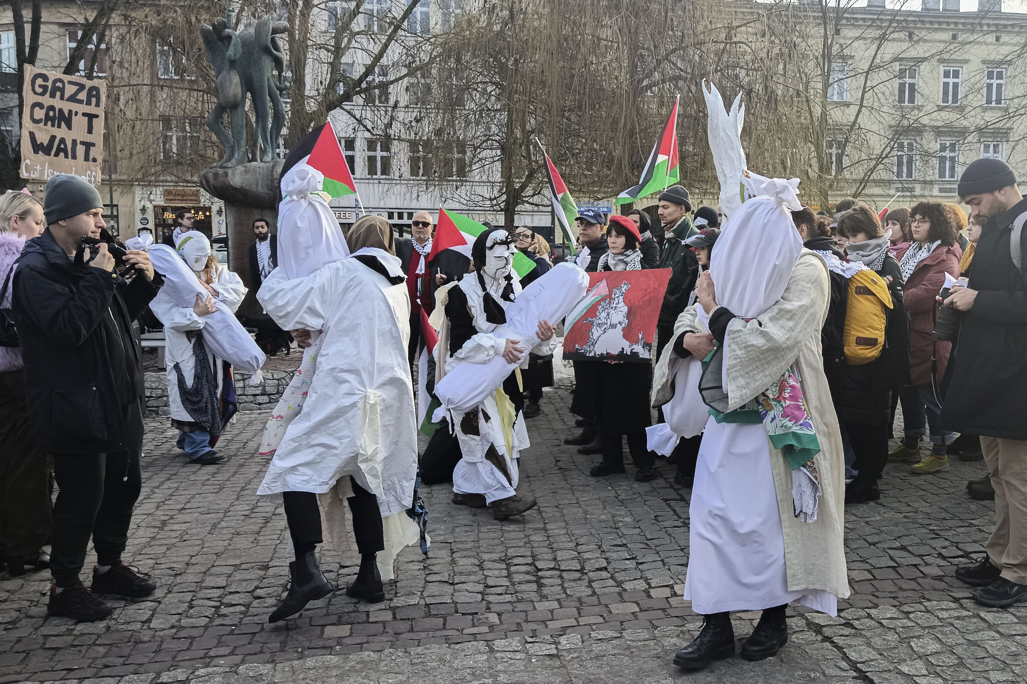CRACOVIA (POLONIA), 26/01/2025.-En la víspera del 80 aniversario de la liberación de Auschwitz cientos de personas se manifestaron este domingo en Cracovia (sur) para llamar la atención sobre la situación en Gaza, que compararon con la de los guetos polacos bajo la invasión nazi. En la céntrica plaza Wolnica, un grupo de académicos leyó un comunicado acusando a Israel de cometer una "masacre" contra los palestinos y comparando la situación en Oriente Medio con la ocupación de Polonia en el siglo XIX, cuando el territorio polaco estuvo ocupado por potencias extranjeras. La manifestación estuvo precedida de una "performance" que representaba el sufrimiento de los habitantes de la franja de Gaza y la muerte de civiles a manos del Ejército israelí.EFE/ Miguel Ángel Mayo Macías