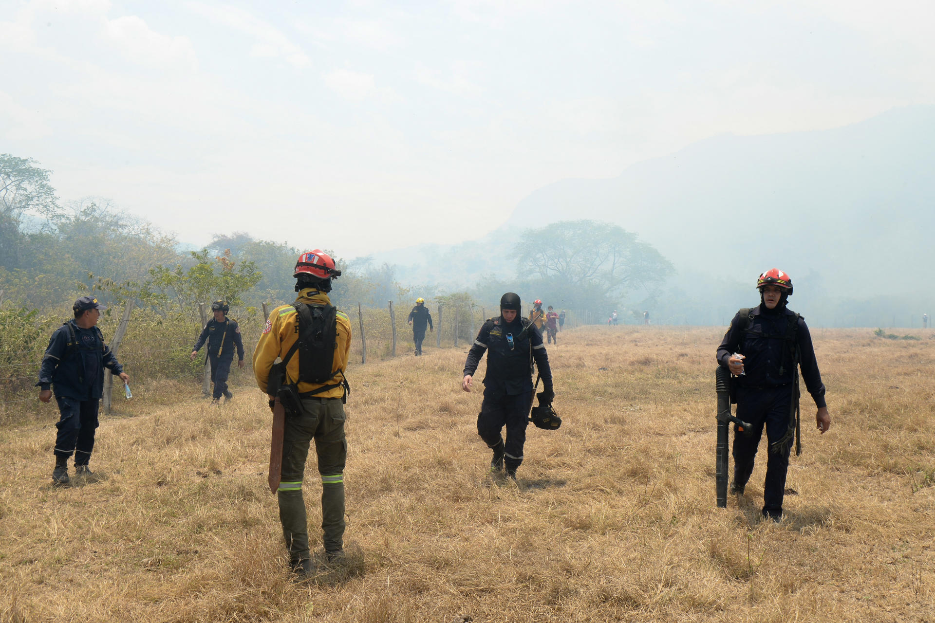 Integrantes de los cuerpos de bomberos de los departamentos del Tolima y el Huila trabajan en la contención de los incendios forestales, que continúan expandiéndose.
