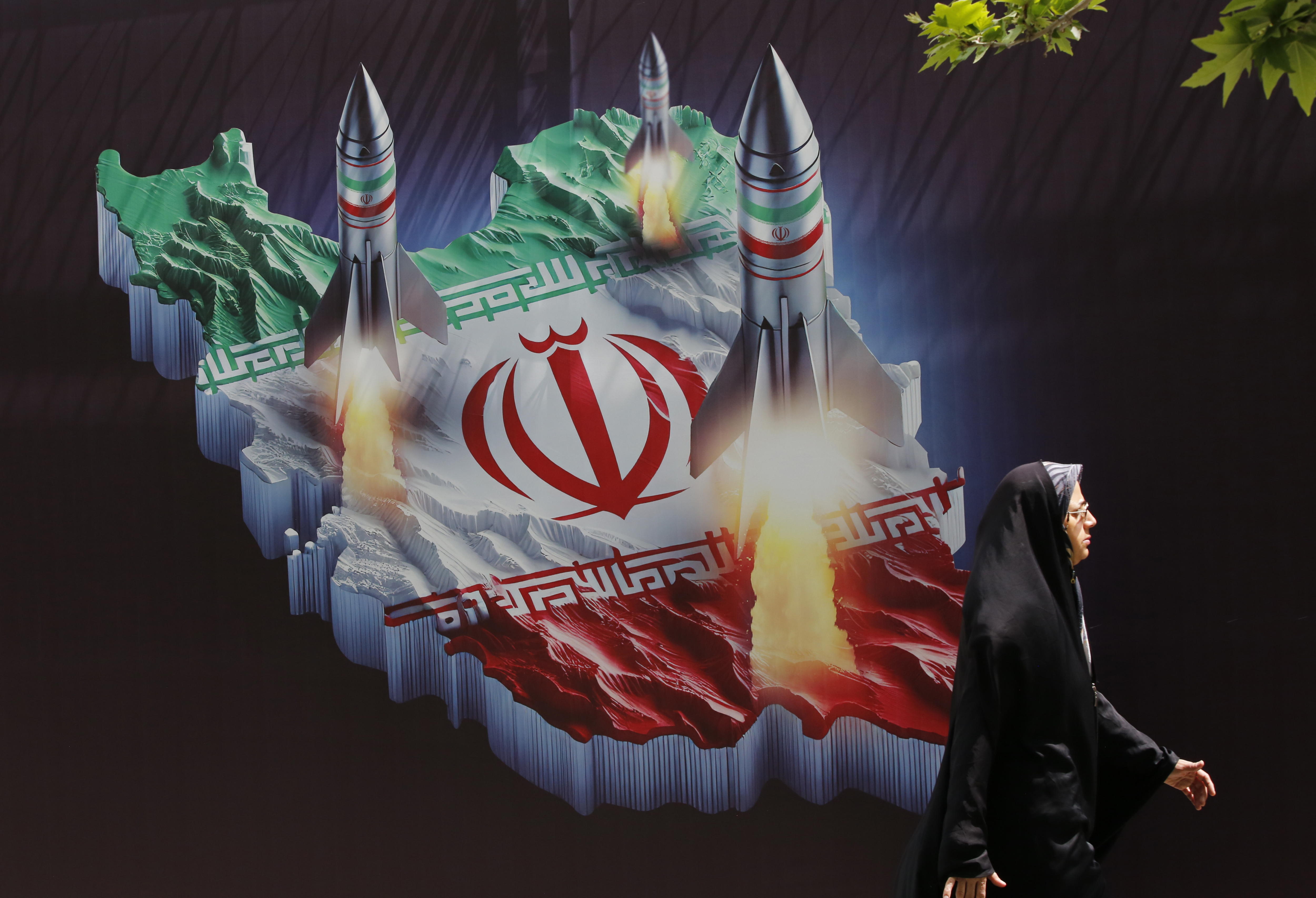 Tehran (Iran (islamic Republic Of)), 16/04/2024.- An Iranian woman walks past an anti-Israel banner carrying pictures of Iranian missiles, in Tehran, Iran, 16 April 2024. Iranian President Ebrahim Raisi on 14 April said any new targeting of his country will be met with stronger response, after Iran's Islamic Revolutionary Guards Corps (IRGC) launched drones and rockets towards Israel late on 13 April. The Israeli Chief of the General Staff LTG Herzi Halevi said on 15 April the Iranian launch of missiles and drones against Israel will be met with a response. (Teherán) EFE/EPA/ABEDIN TAHERKENAREH