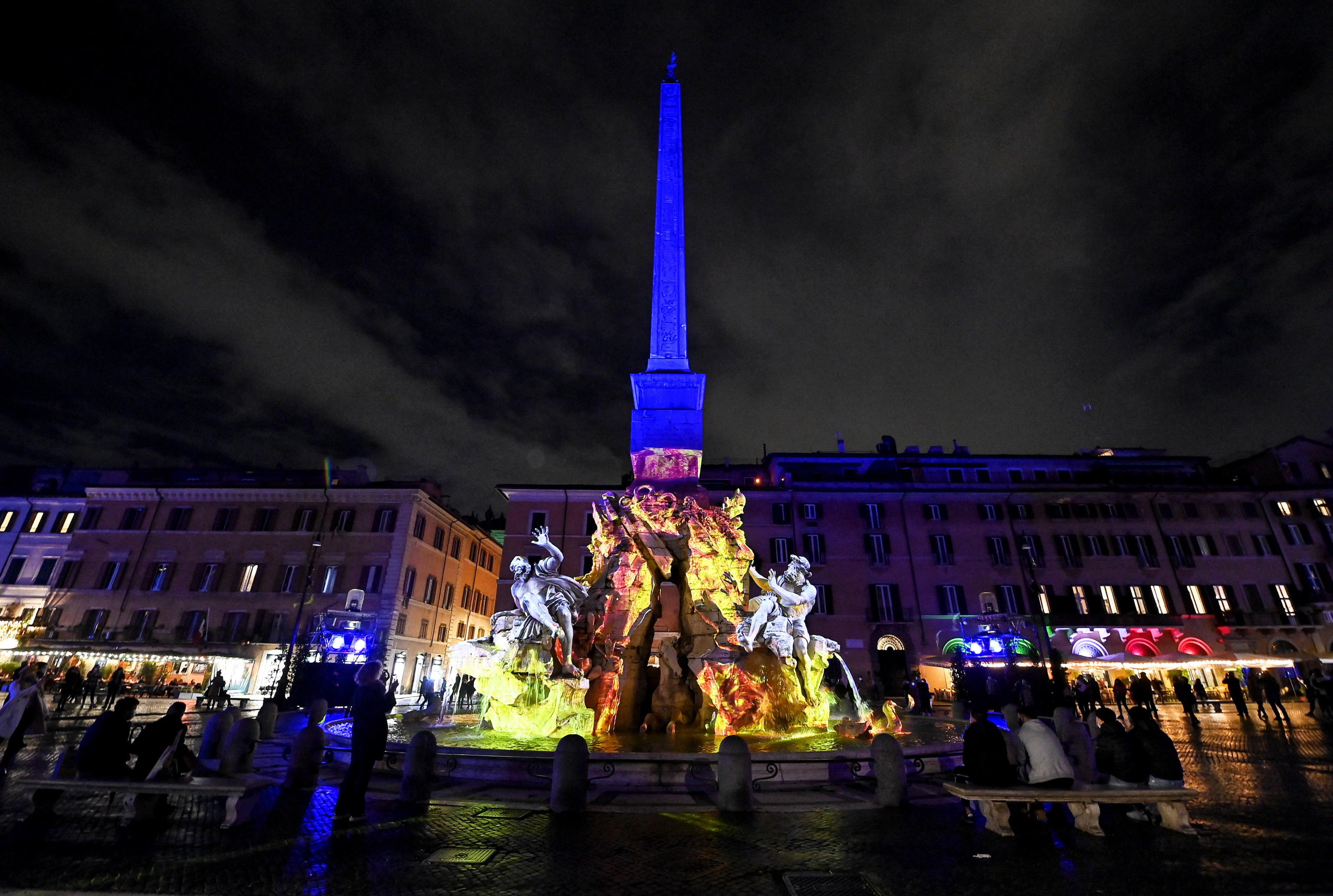 Las tres fuentes históricas en piazza Navona iluminadas con espectáculos de luces en Roma, Italia.