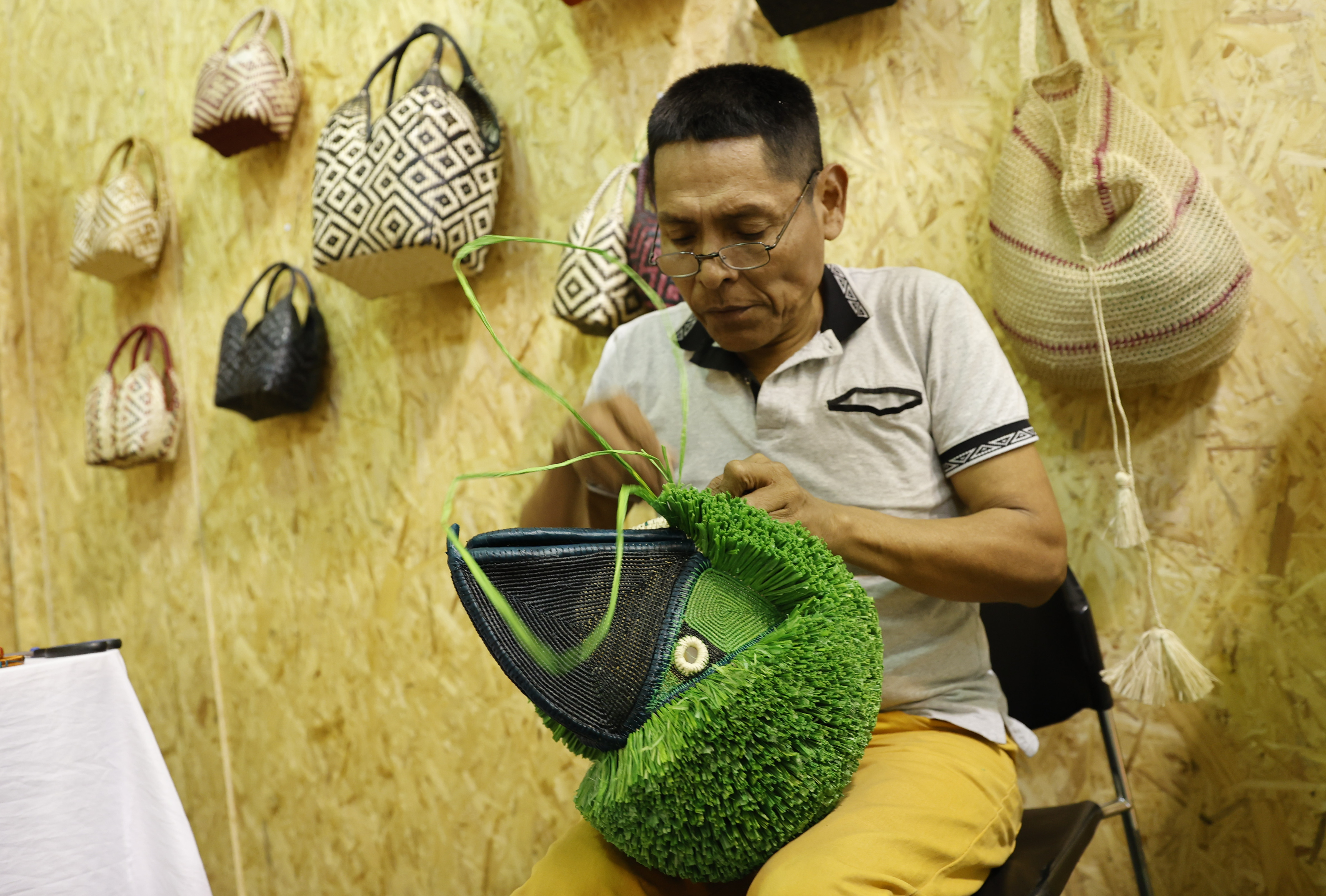 AME4027. BOGOTÁ (COLOMBIA), 12/12/2023.- Un hombre realiza un tejido con Wérregue del Chocó expuestos en Expoartesanías, la feria de artesanías más grande de Colombia, que reúne a 900 artesanos de todo el país que en ocho pabellones de Corferias, hoy en Bogotá (Colombia). La feria tendrá lugar hasta el 20 de diciembre. EFE/ Mauricio Dueñas Castañeda