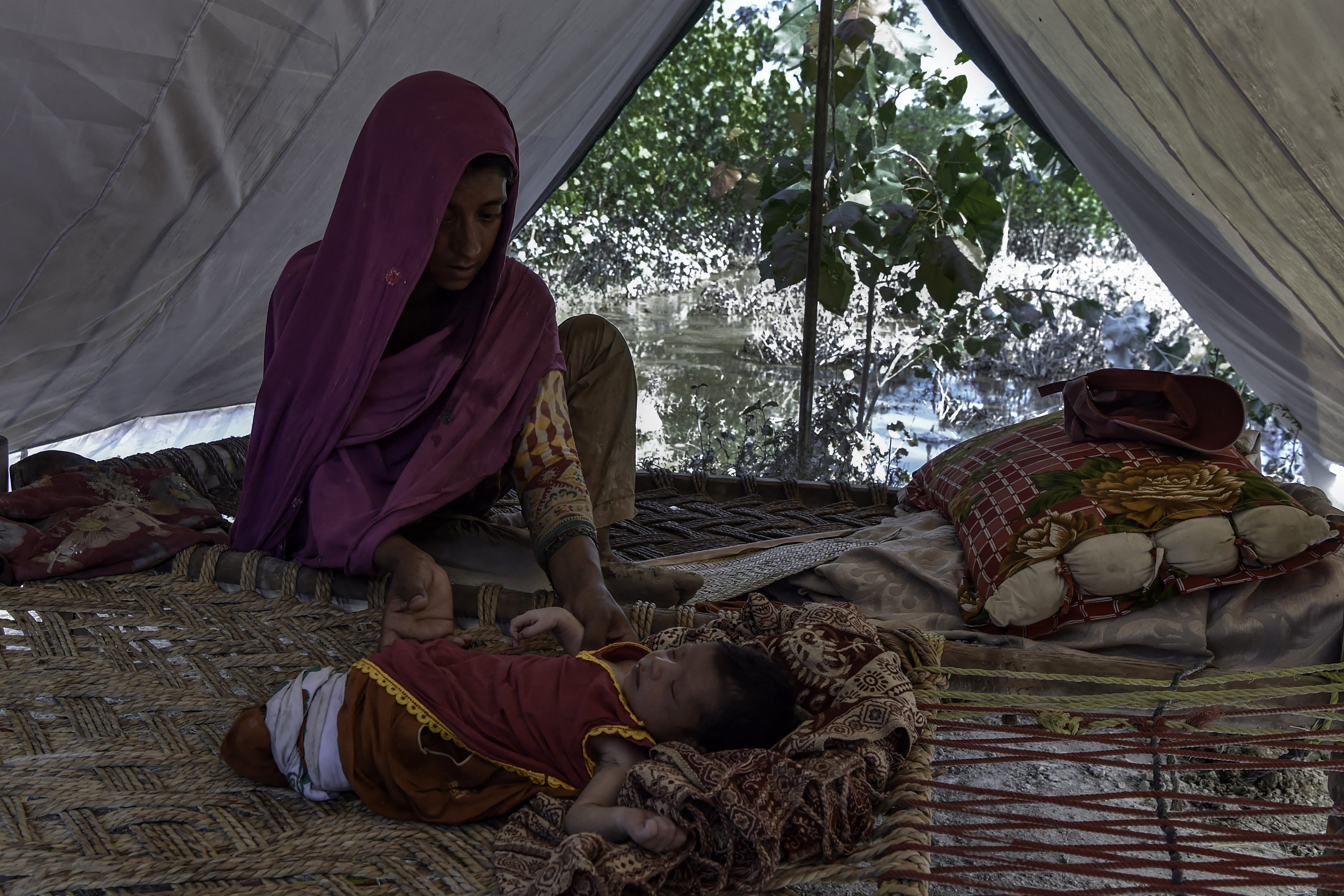 Una madre y su bebé sobreviven entre el barro tras las inundaciones en Pakistán