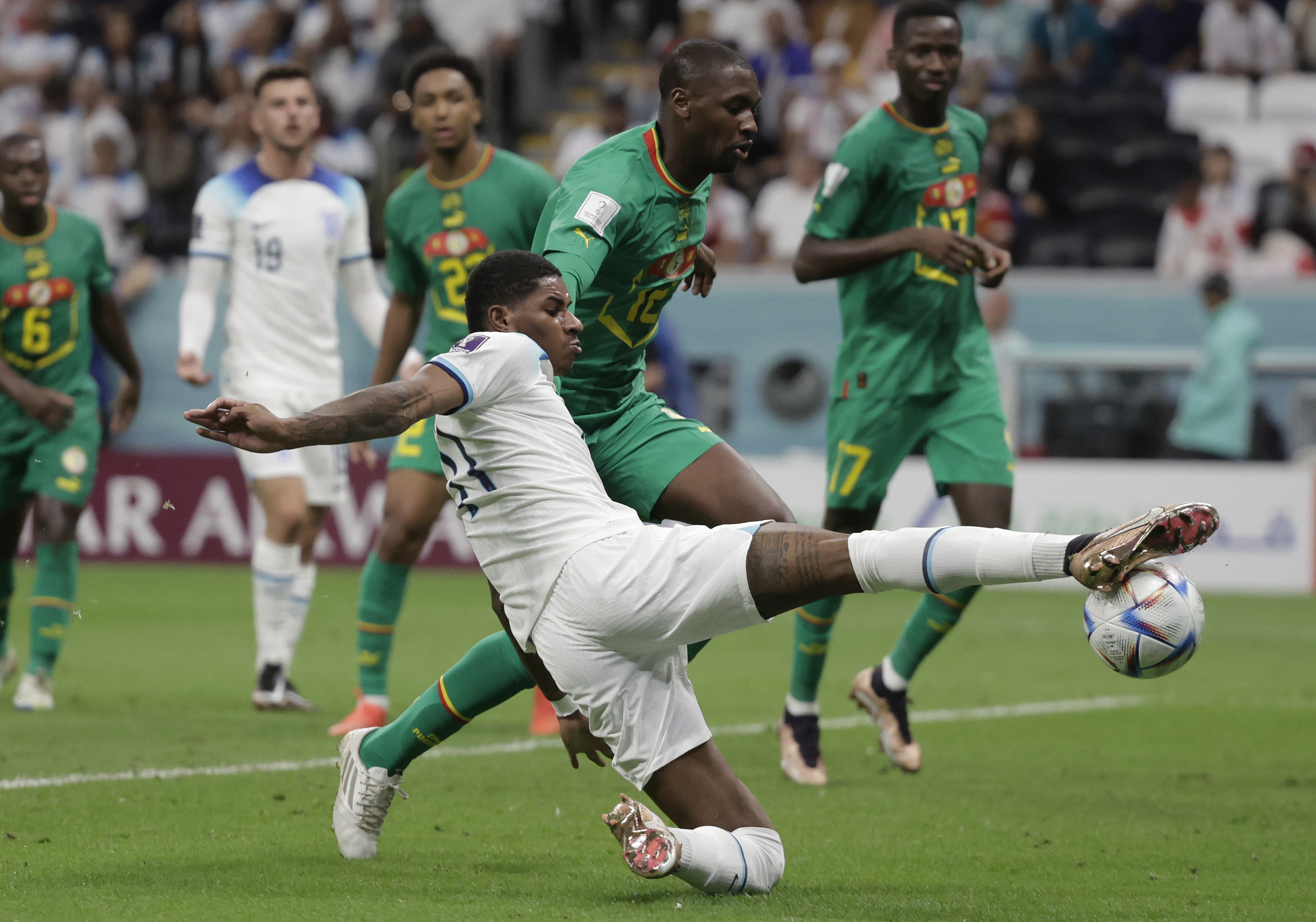 . JOR (CATAR), 04/12/2022.- Marcus Rashford (abajo) de Inglaterra disputa un balón hoy, en un partido de los octavos de final del Mundial de Fútbol Qatar 2022 entre Inglaterra y Senegal en el estadio Al Bait en Jor (Catar). EFE/Antonio Lacerda