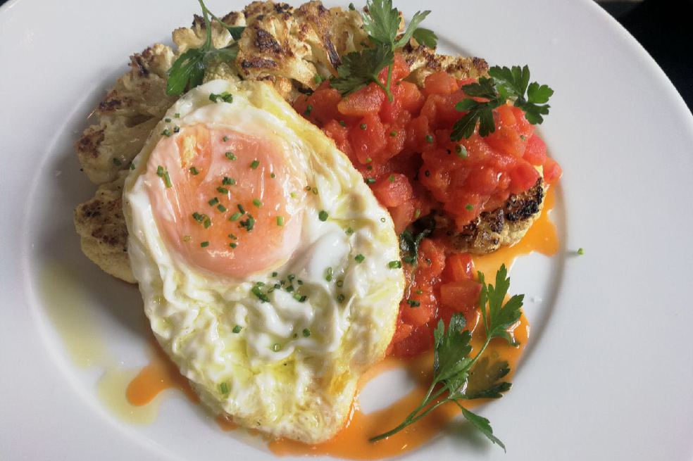 ¿Cómo preparar coliflor asada con salteado de tomate fresco y huevo frito?