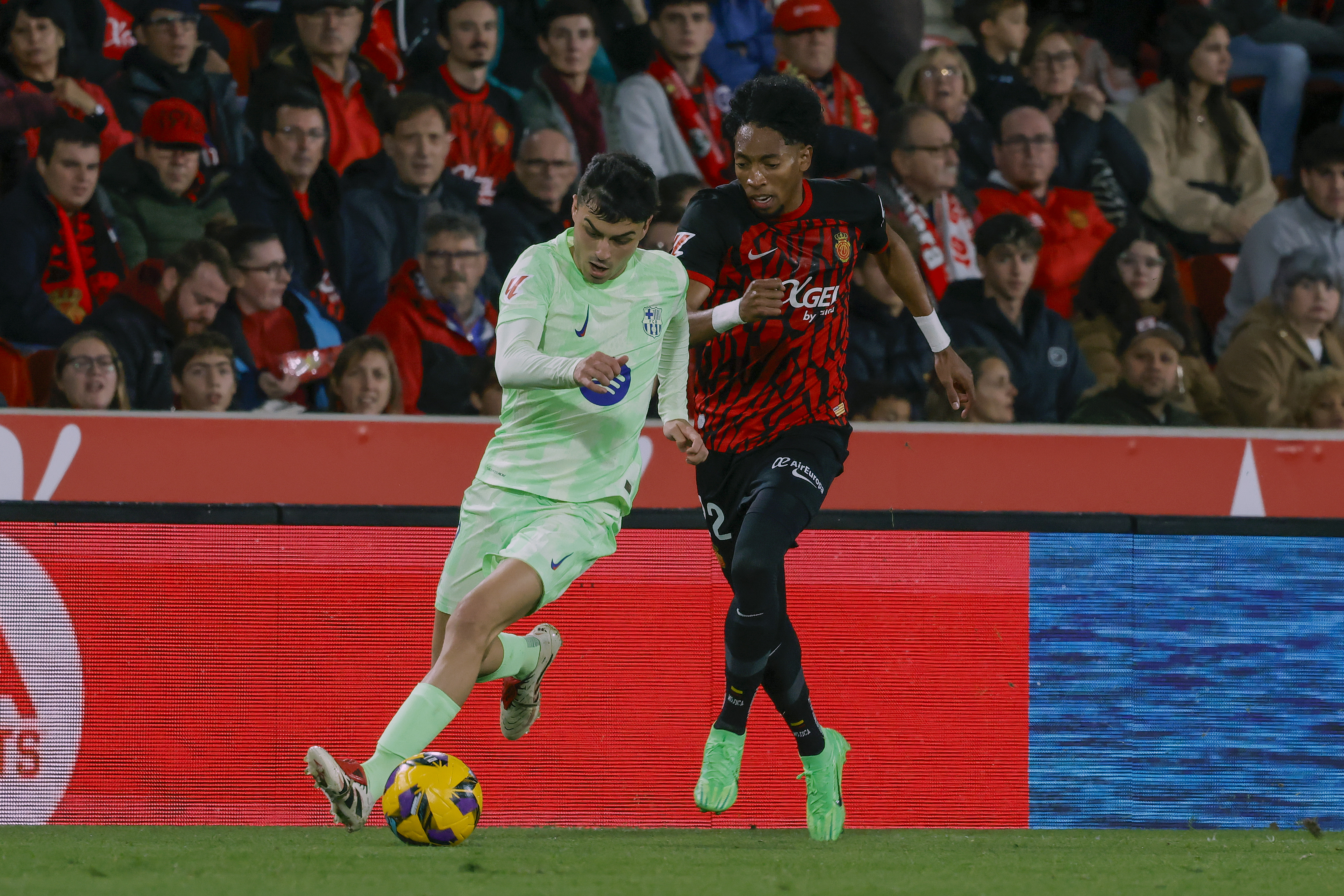 PALMA, 03/12/2024.- El centrocampista del Barcelona Pedri (i) disputa un balón ante el defensa colombiano del Mallorca Johan Mojica, durante el partido de LaLiga de la jornada 19 entre el Real Mallorca y el Barcelona, que se disputa este martes en el estadio de Son Moix.- EFE/ Cati Cladera