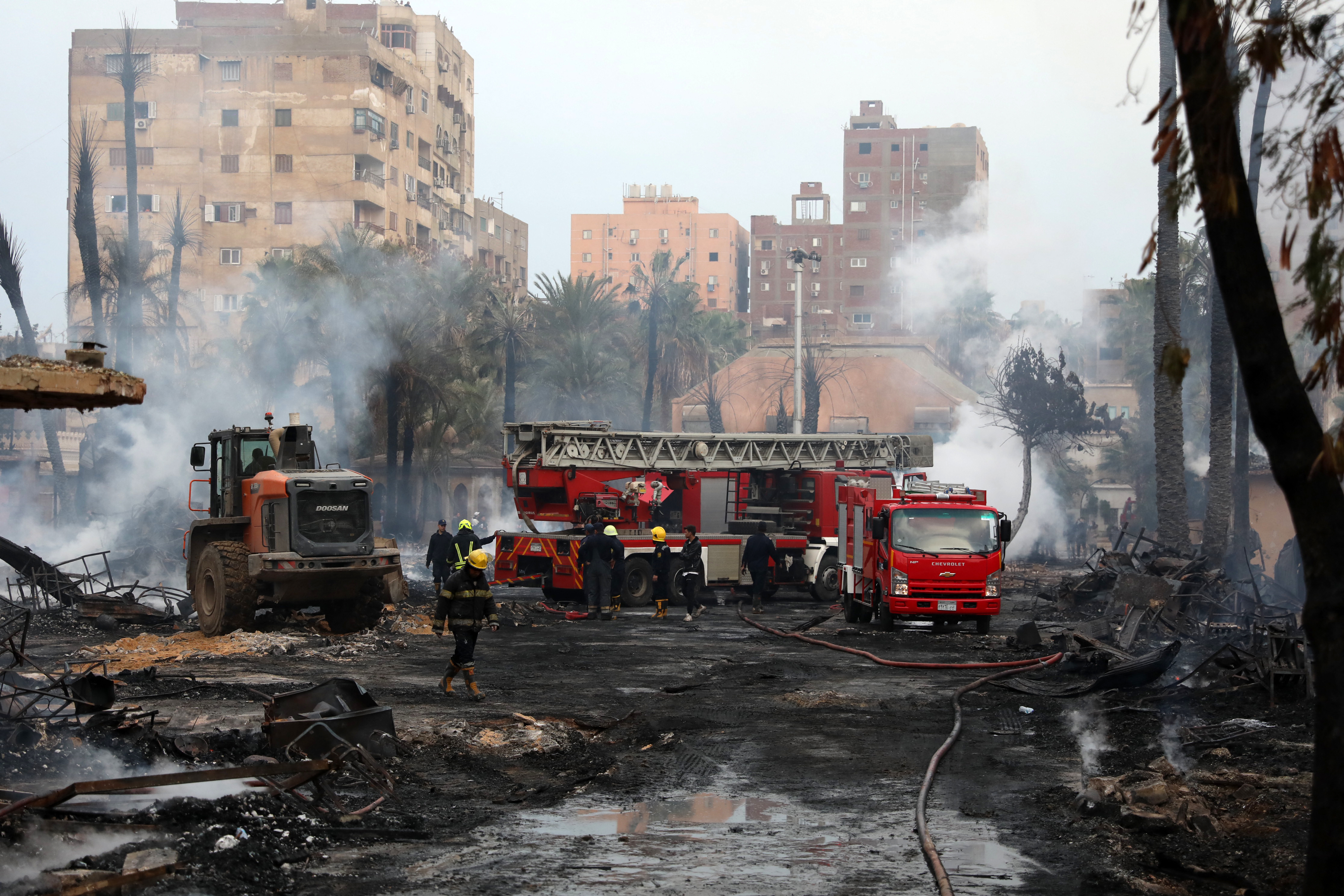 Los bomberos enfrían el área que aún arde después de un incendio en el estudio Al-Ahram y los edificios circundantes en el distrito de Giza en El Cairo el 16 de marzo de 2024.