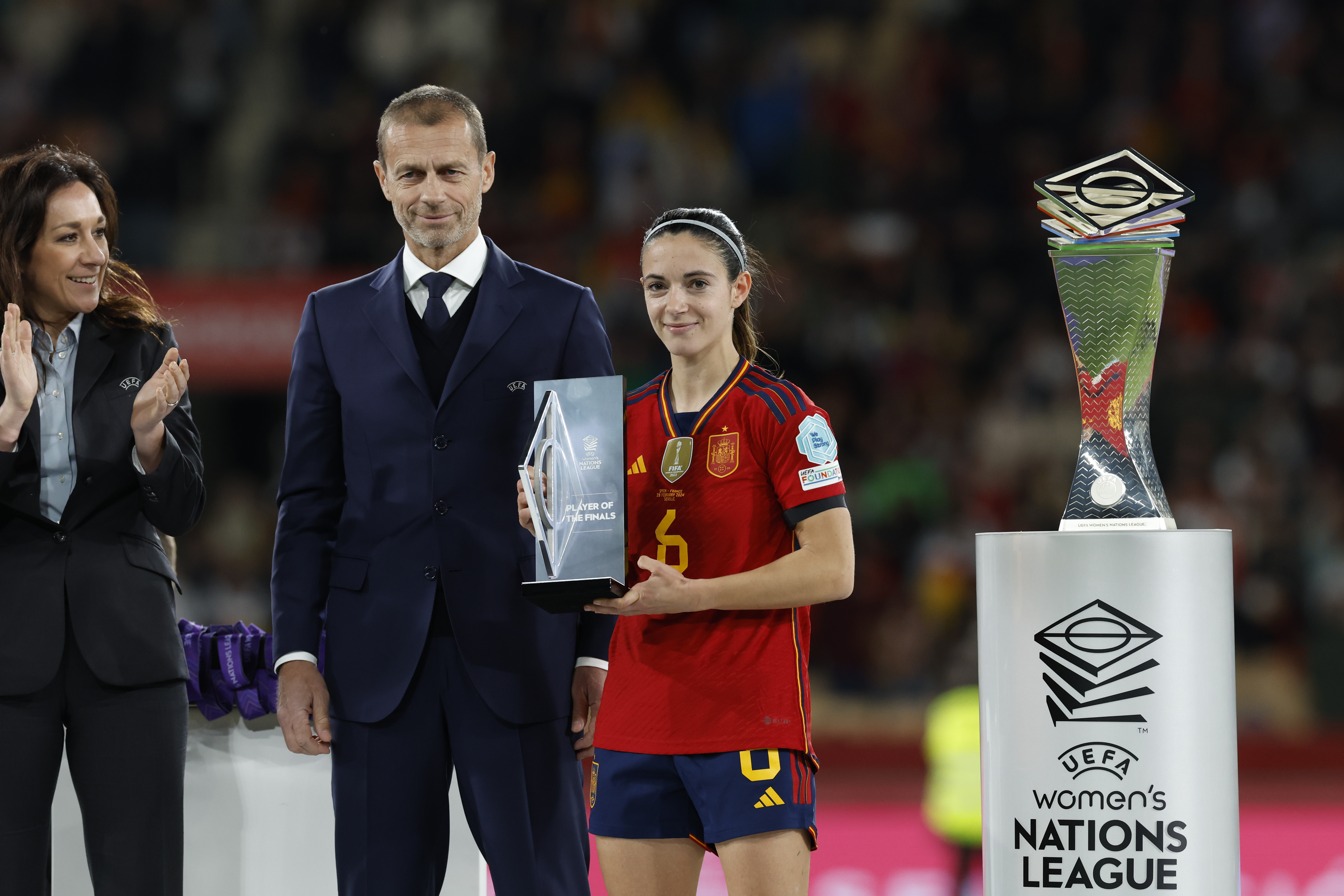 SEVILLA, 28/02/2024.- La centrocampista de la selección española Aitana Bonamtí (d) recibe el premio a la mejor jugadora del partido de manos del presidente de la UEFA, Aleksander Ceferin (i), tras la final de la Liga de Naciones Femenina, este miércoles en el Estadio de La Cartuja en Sevilla. EFE/Julio Muñoz