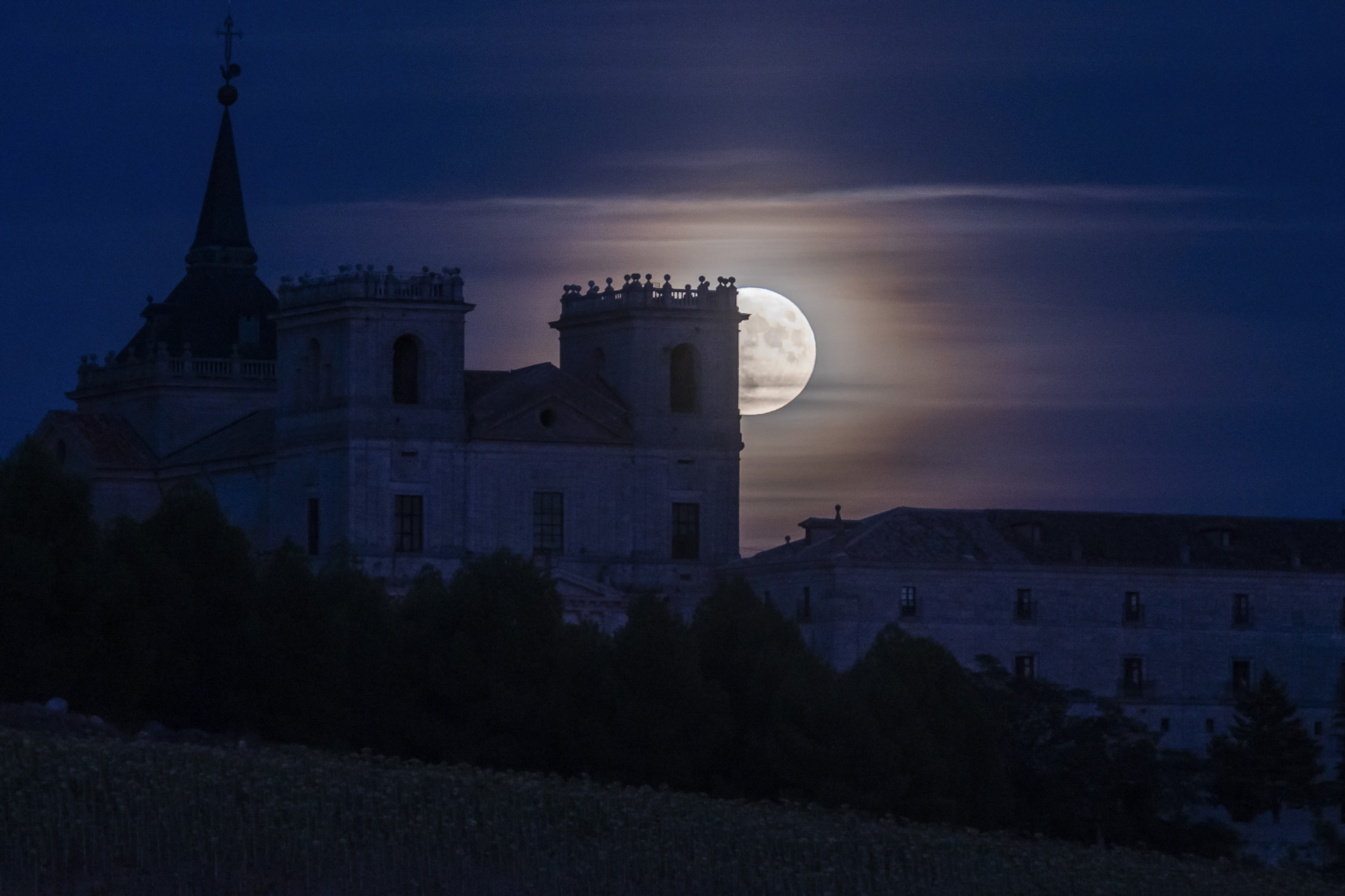 UCLÉS (CUENCA), 30/08/2023.- La superluna azul sale tras el Monasterio de Uclés, este miércoles en la provincia de Cuenca. EFE/ Fernando Villar