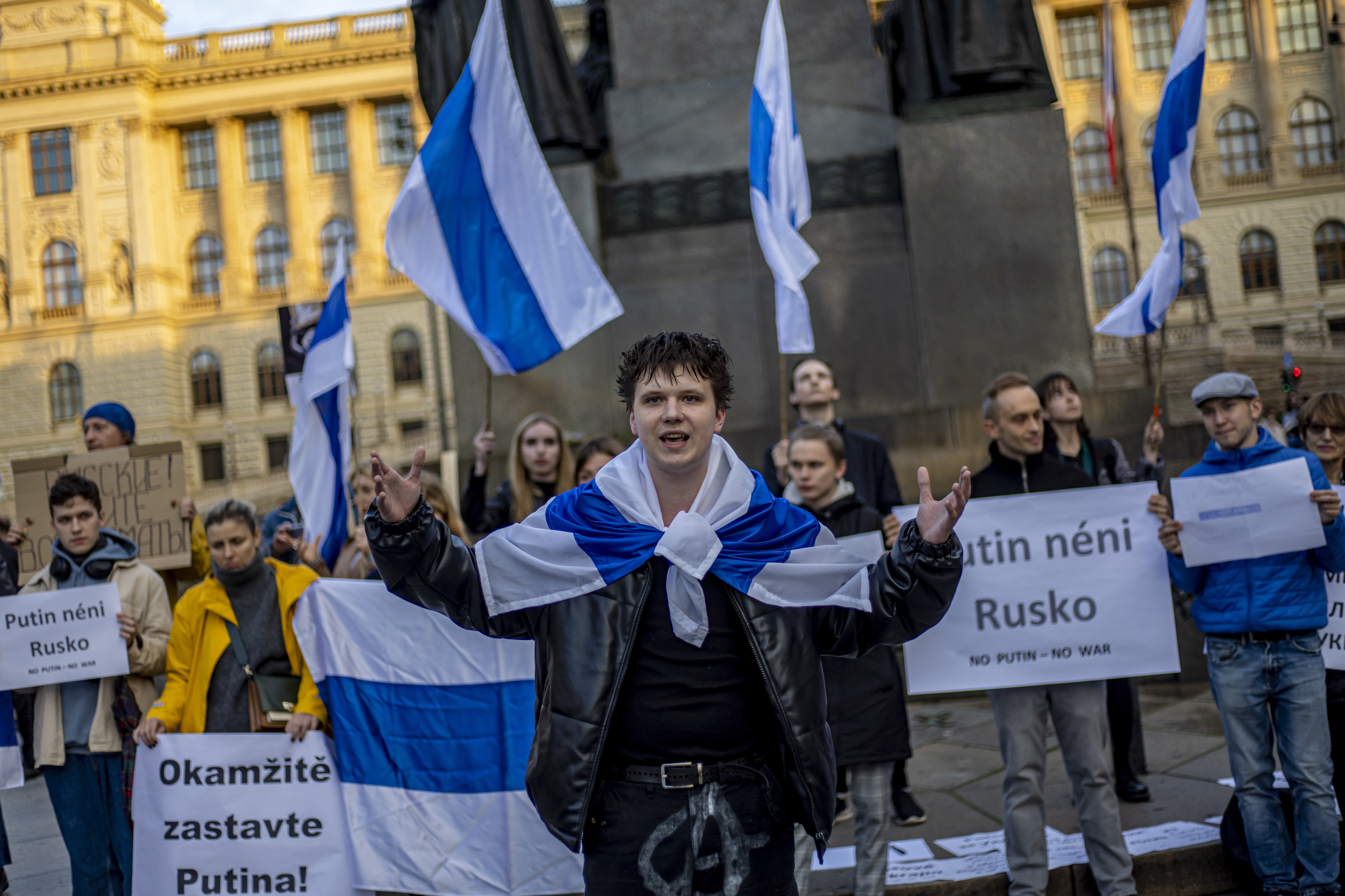 Manifestantes rusos en Praga sostienen pancartas y ondean banderas en colores blanco y azul, que representan la bandera tricolor nacional rusa, con rojo omitido, reemplazado por blanco, utilizado para expresarse contra la guerra.