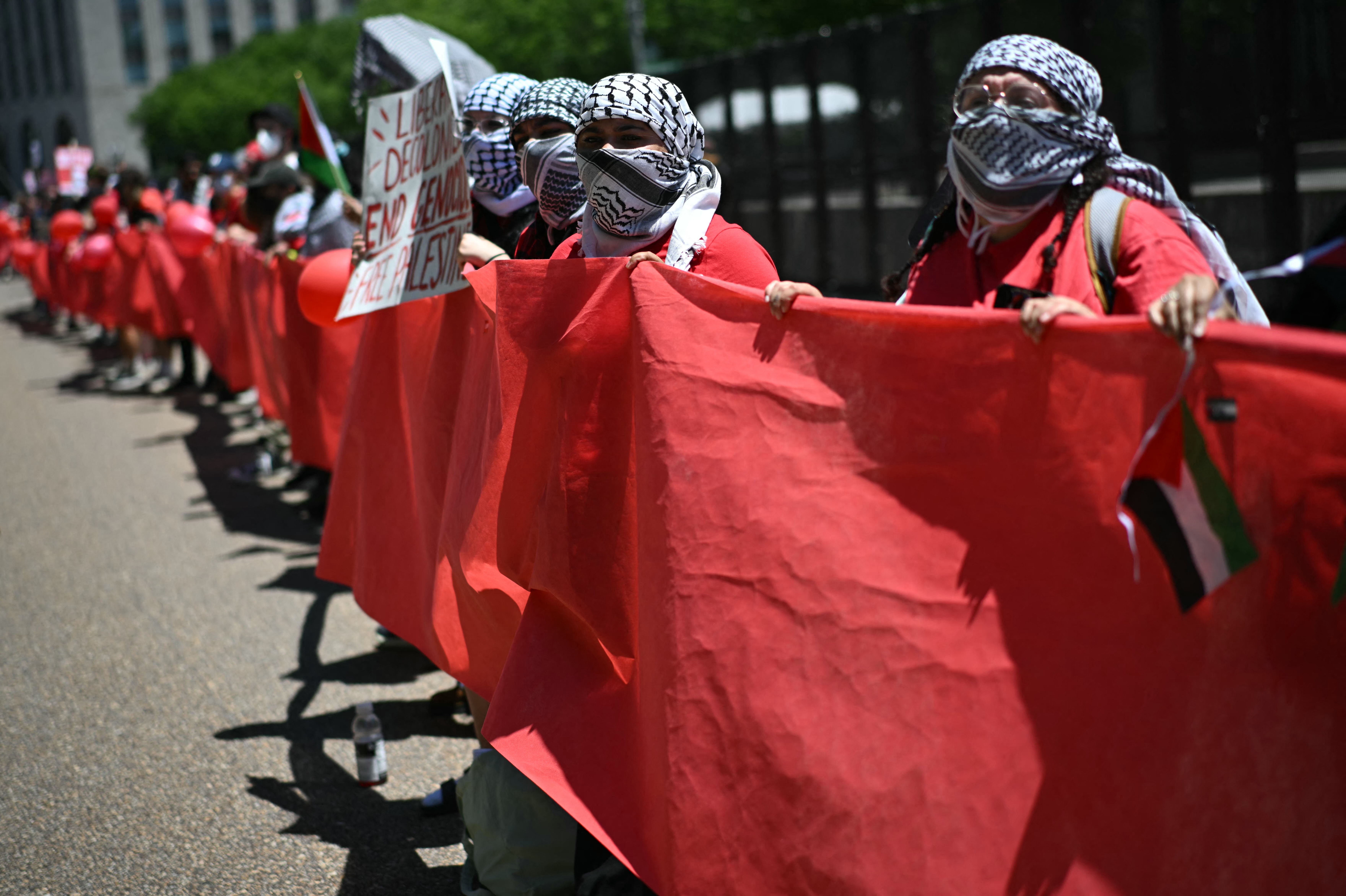 Pro-Palestinian demonstrators, in formation holding a "red line," rally near the White House in Washington, DC, on June 8, 2024 to protest against Israel's actions in Gaza.  (Photo by Mandel NGAN / AFP)