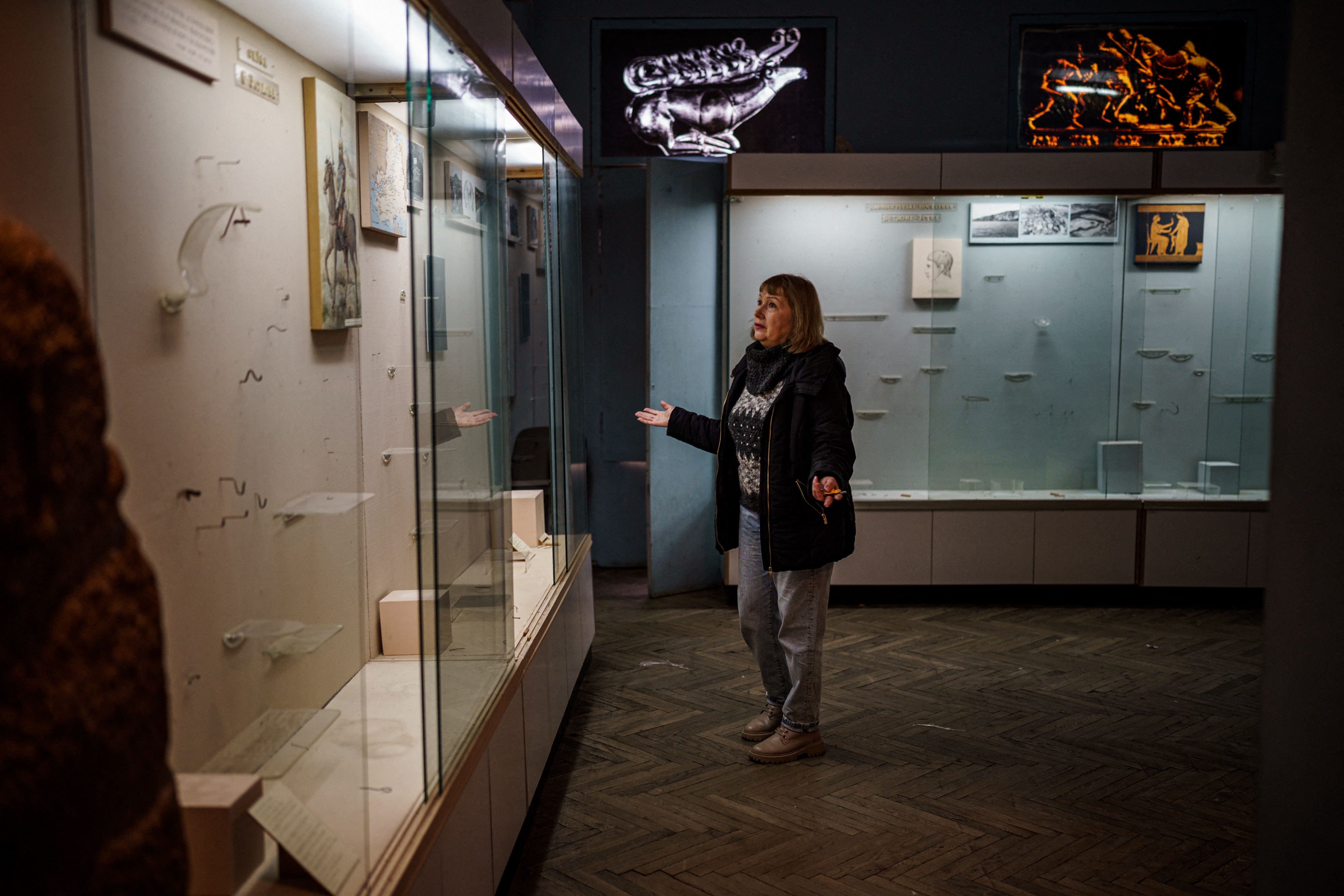 Olga Honcharova, temporary director of the Kherson Regional Museum, specialising in local history and natural history shows shows an empty glass display cases in Kherson, amid the Russian invasion of Ukraine. - Russian military forces and civilians operating under their orders pillaged thousands of valuable artifacts and artworks from two museums, a cathedral, and a national archive in Kherson, before withdrawing after an 8-month occupation of the city, Human Rights Watch said on December 20, 2022. (Photo by Dimitar DILKOFF / AFP)