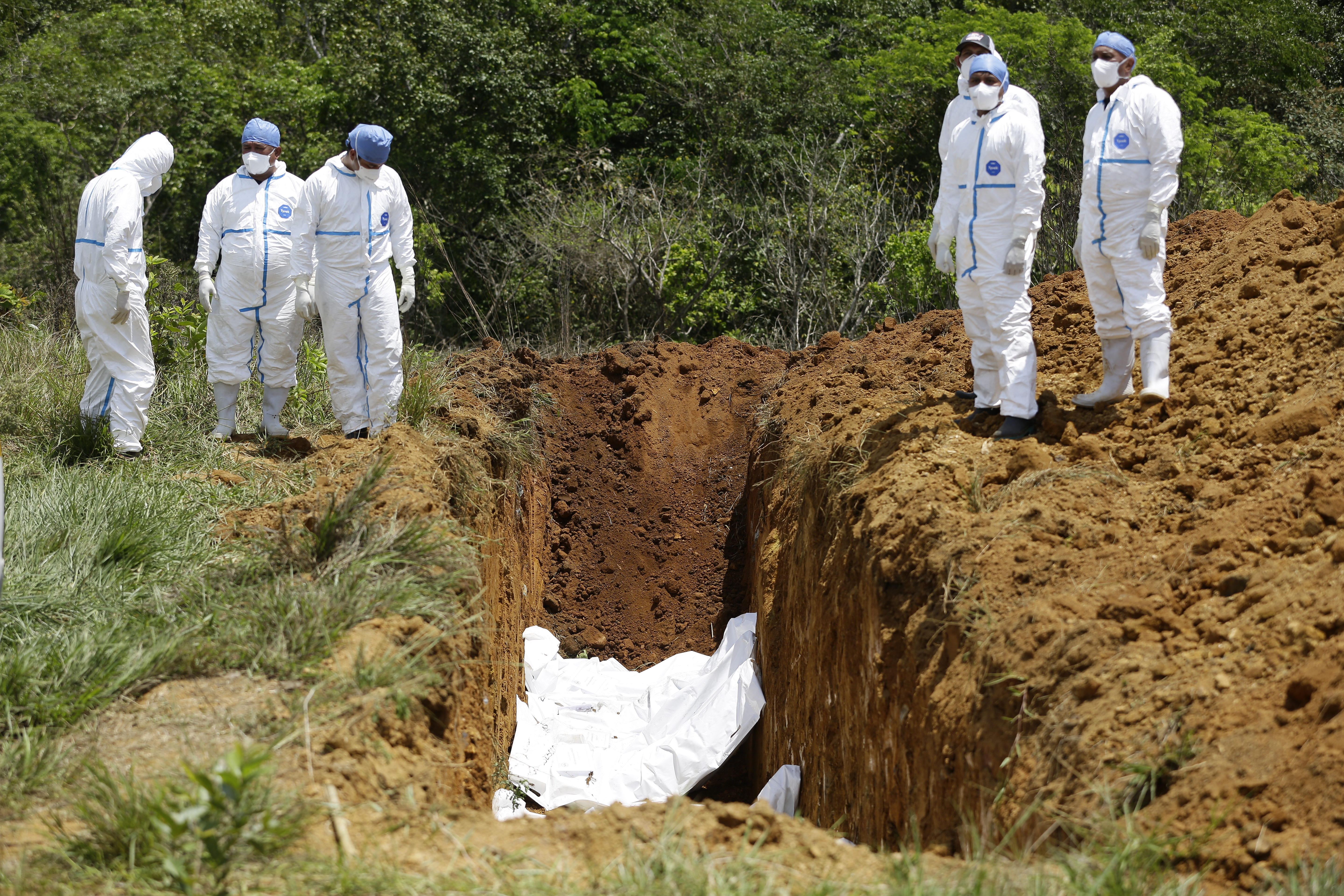 -FOTODELDÍA- AME3236. DAVID (PANAMÁ), 17/03/2023.- Trabajadores forenses realizan el entierro de los cuerpos de migrantes fallecidos durante un accidente en autobús el pasado mes de febrero, hoy en David (Panamá). El pasado 15 de febrero un autobús que trasladaba a 66 migrantes desde un albergue en la selvática provincia de Darién, en la frontera con Colombia, hasta otro similar en el norteño Chiriquí, limítrofe con Costa Rica, se accidentó causando la muerte de 37 migrantes y dos panameños, según los últimos datos oficiales. Los cuerpos que no han sido reclamados por sus familiares serán sepultados este viernes en David, capital de Chiriquí, cerca de donde ocurrió el accidente. EFE/ Bienvenido Velasco
