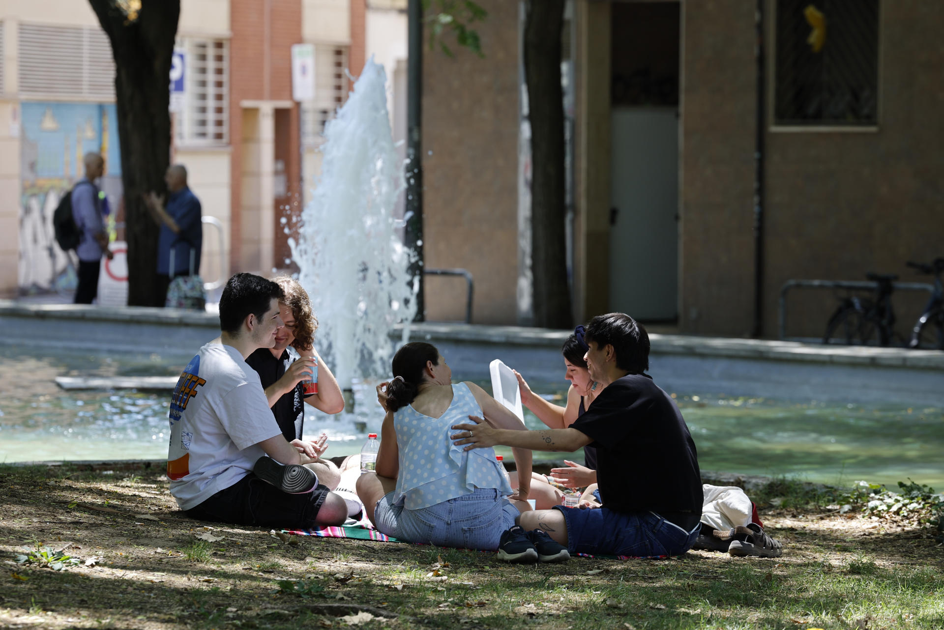 BARCELONA, 29/06/2025.- Unos jóvenes se reúnen a la sombra de un árbol y al lado de una fuente en el parque de la España Industrial en el barrio de Sants en Barcelona este domingo. Cataluña afronta este domingo el segundo día de la primera ola de calor de 2025, que en principio se prolongará hasta el martes, tras una noche tórrida que ha dejado una mínima de 30,4 grados en Portbou (Girona) y de 28 en Barcelona, según los registros del servicio Meteocat. Una ola de calor en la que ayer se registraron 46 grados en El Granado (Huelva), un hecho que nunca se había dado en el mes de junio, ha informado la Agencia Estatal de Meteorología (Aemet) este domingo. EFE/ Toni Albir
