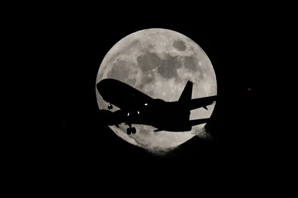 Un avión de pasajeros vuela sobre la luna castor antes de aterrizar en el aeropuerto internacional de San Francisco, fotografiado desde Foster City en California